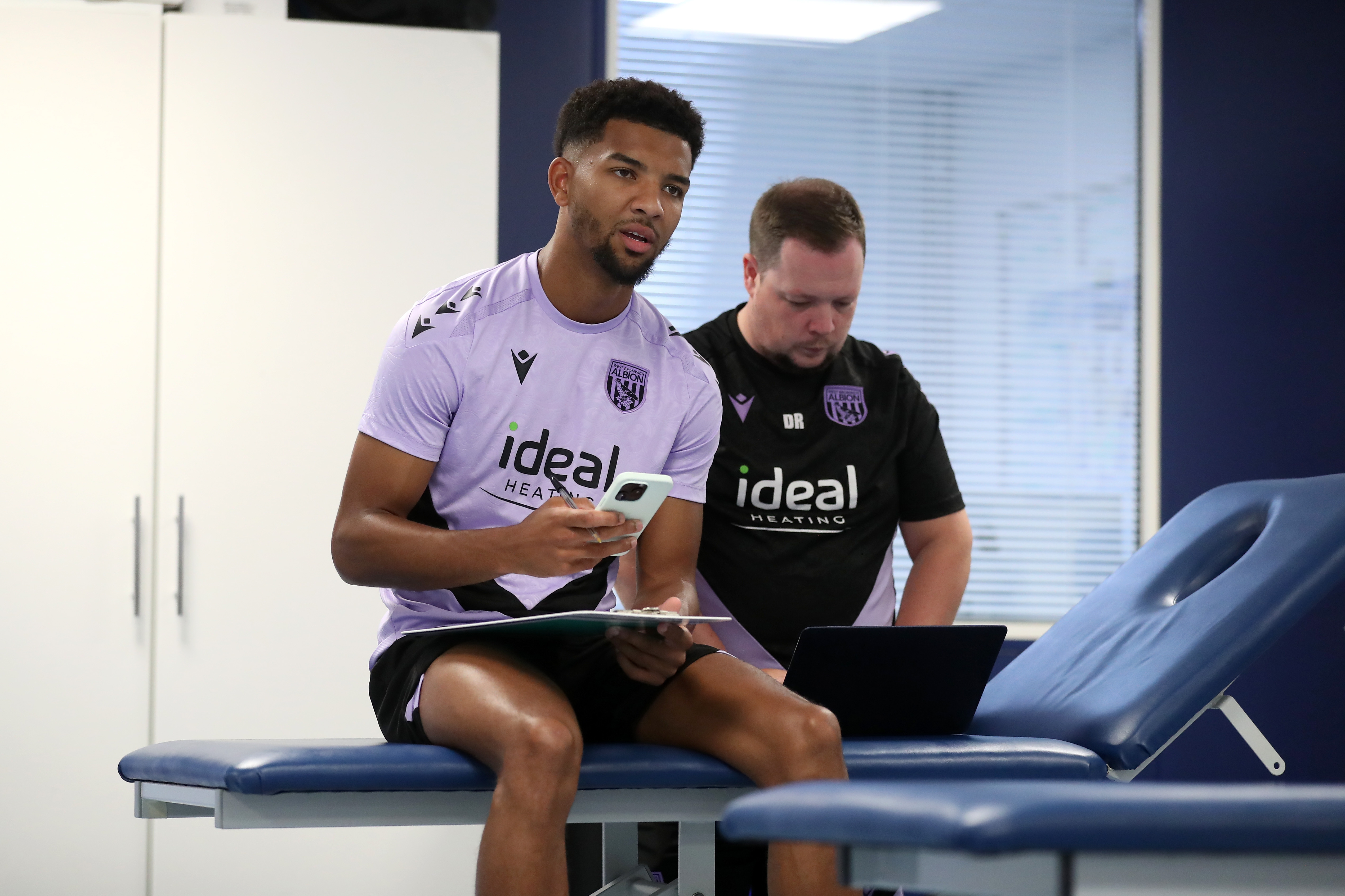 Mason Holgate sat on a physio bed with a member of staff