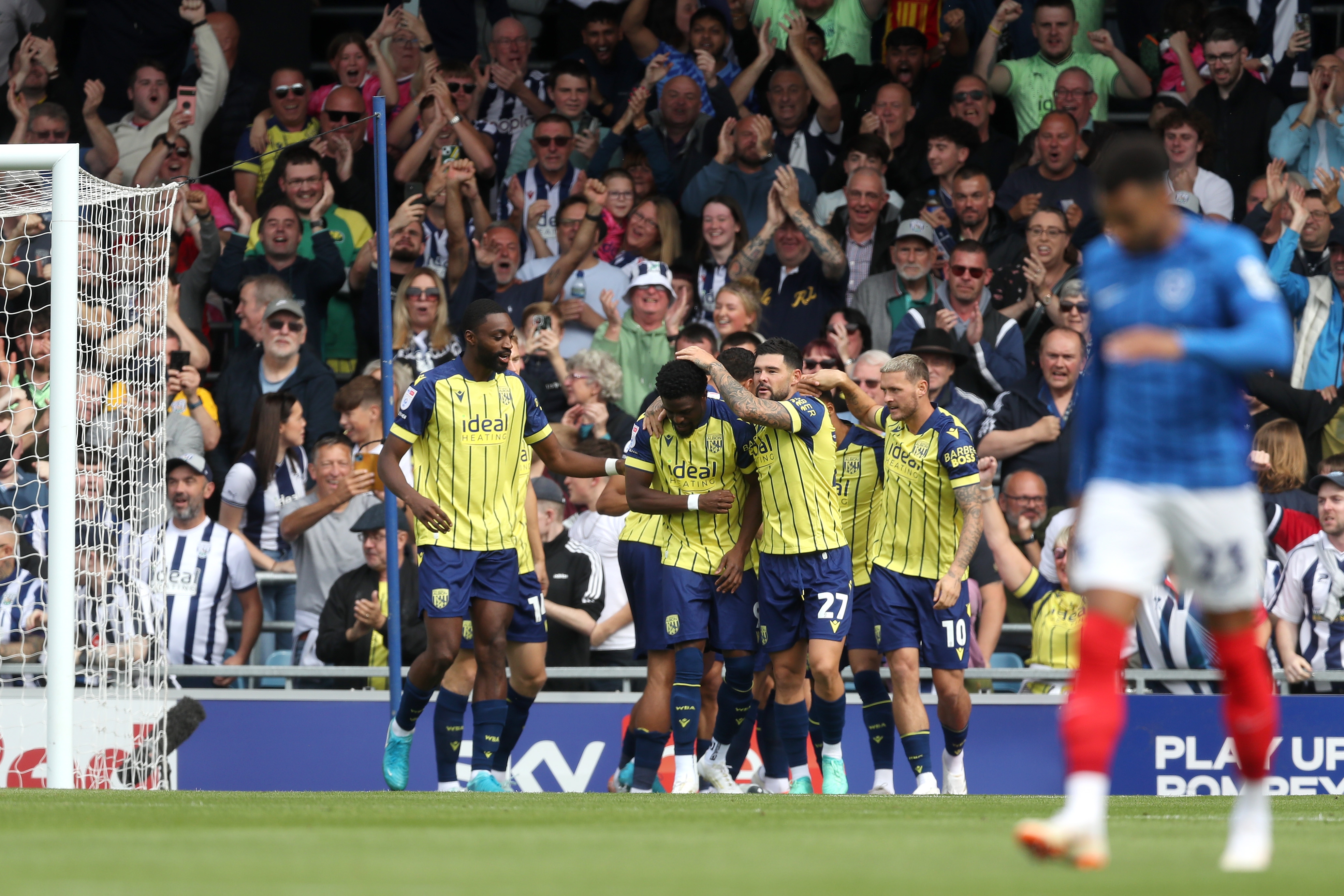 Albion in action against Portsmouth at Fratton Park, in yellow and blue away colours.