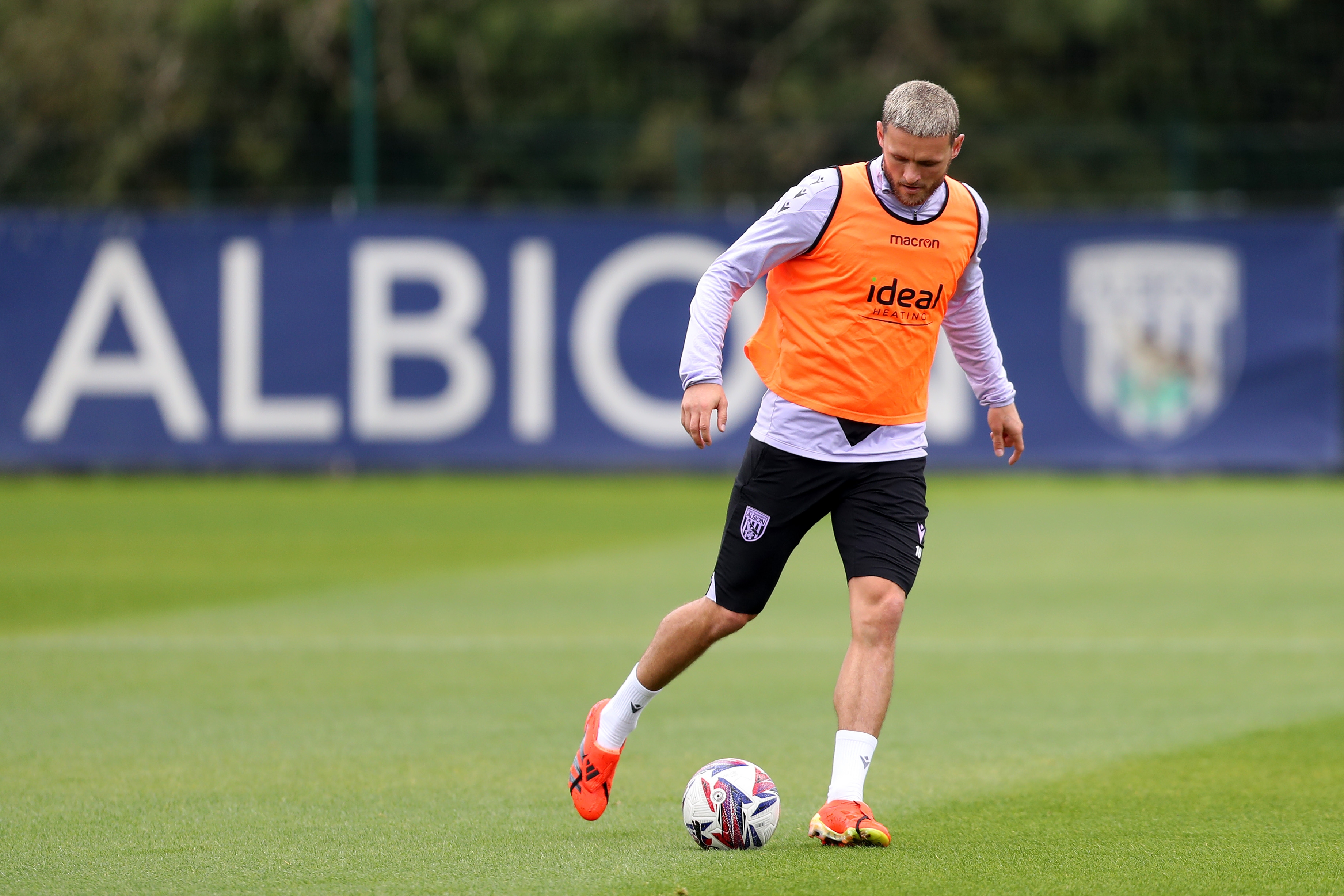 John Swift on the ball during a training session wearing an orange bib