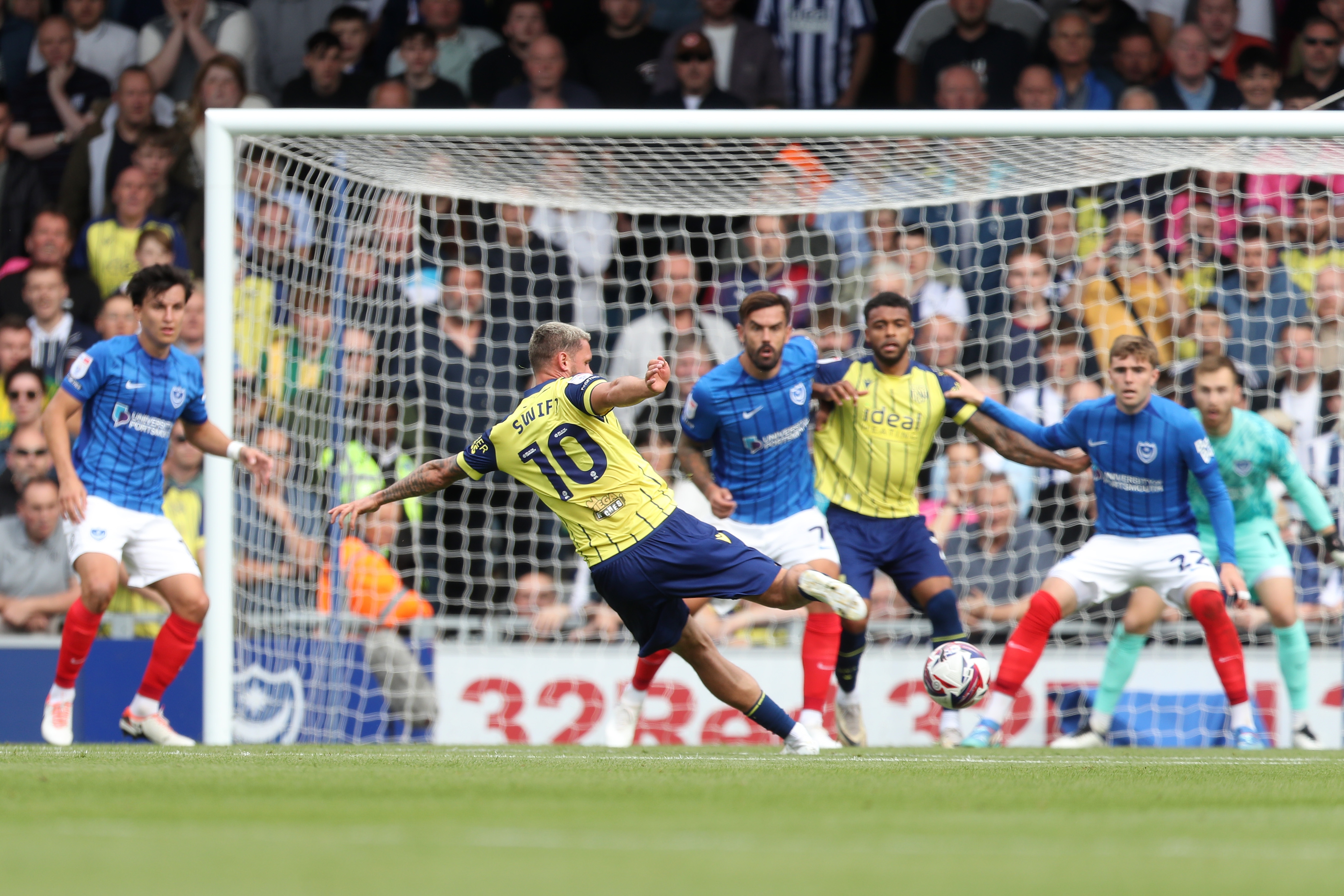 Albion in action against Portsmouth at Fratton Park, in yellow and blue away colours.