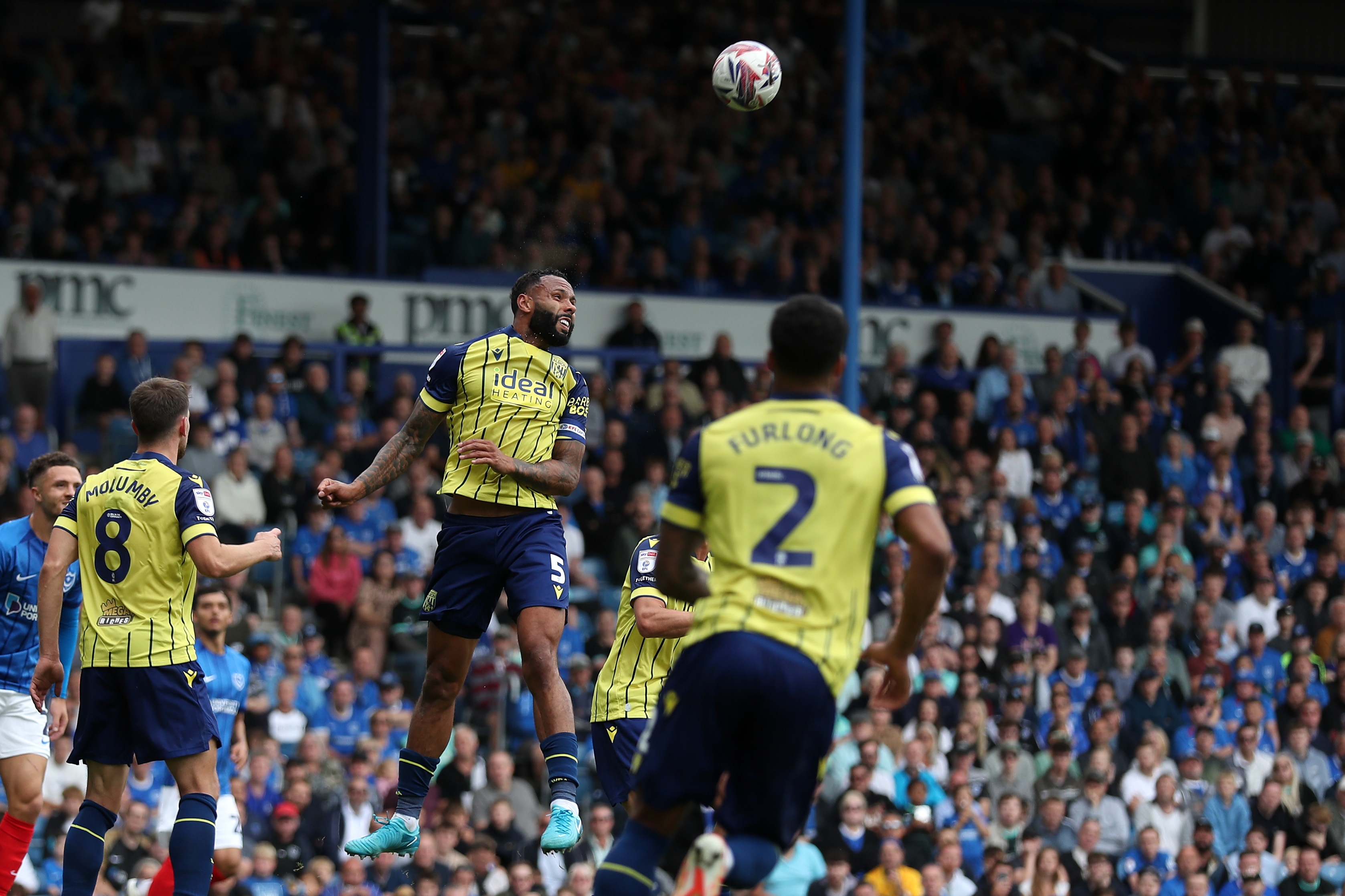 Albion in action against Portsmouth at Fratton Park, in yellow and blue away colours.