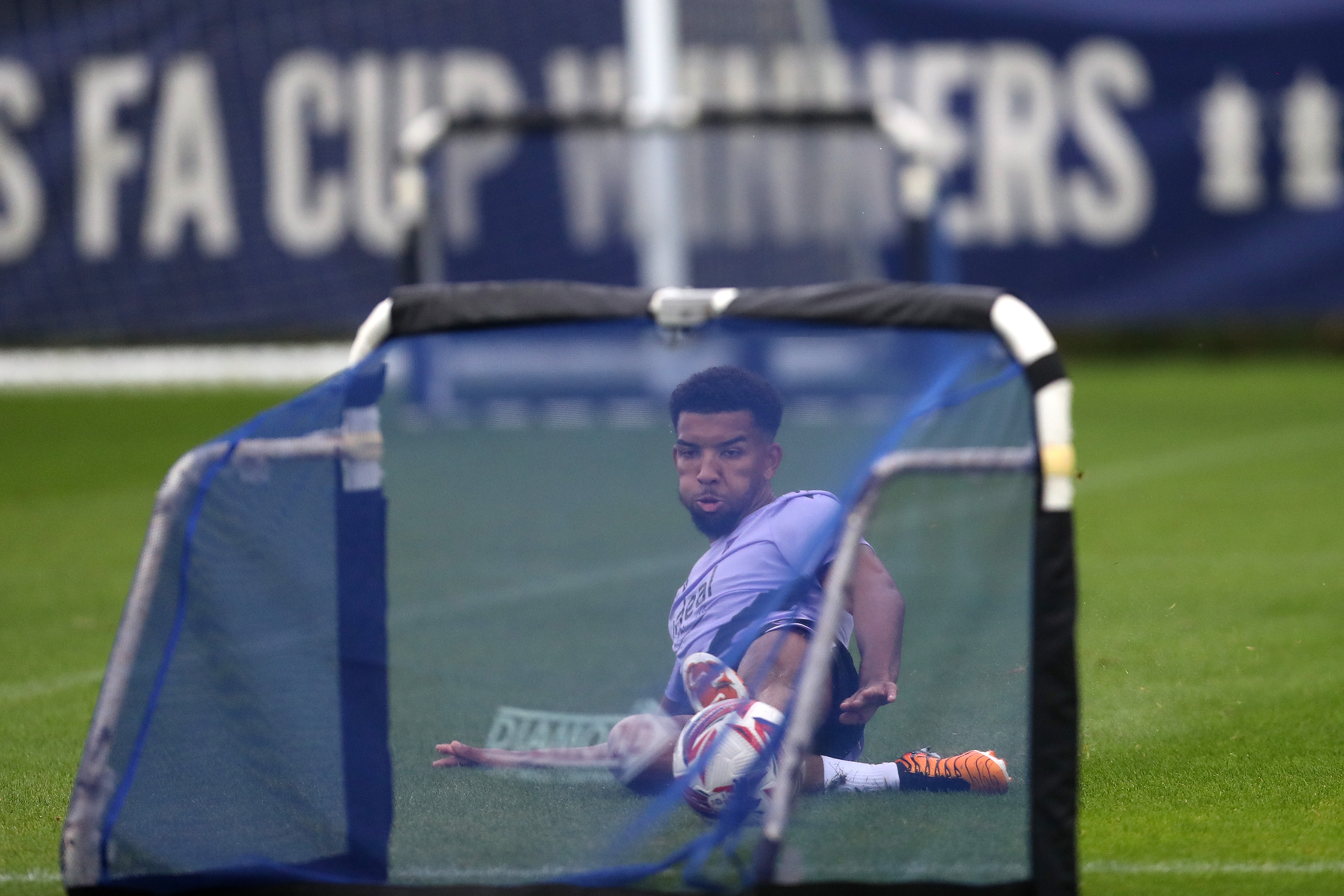 Mason Holgate sliding to reach a ball in front of a mini goal on the training pitch 