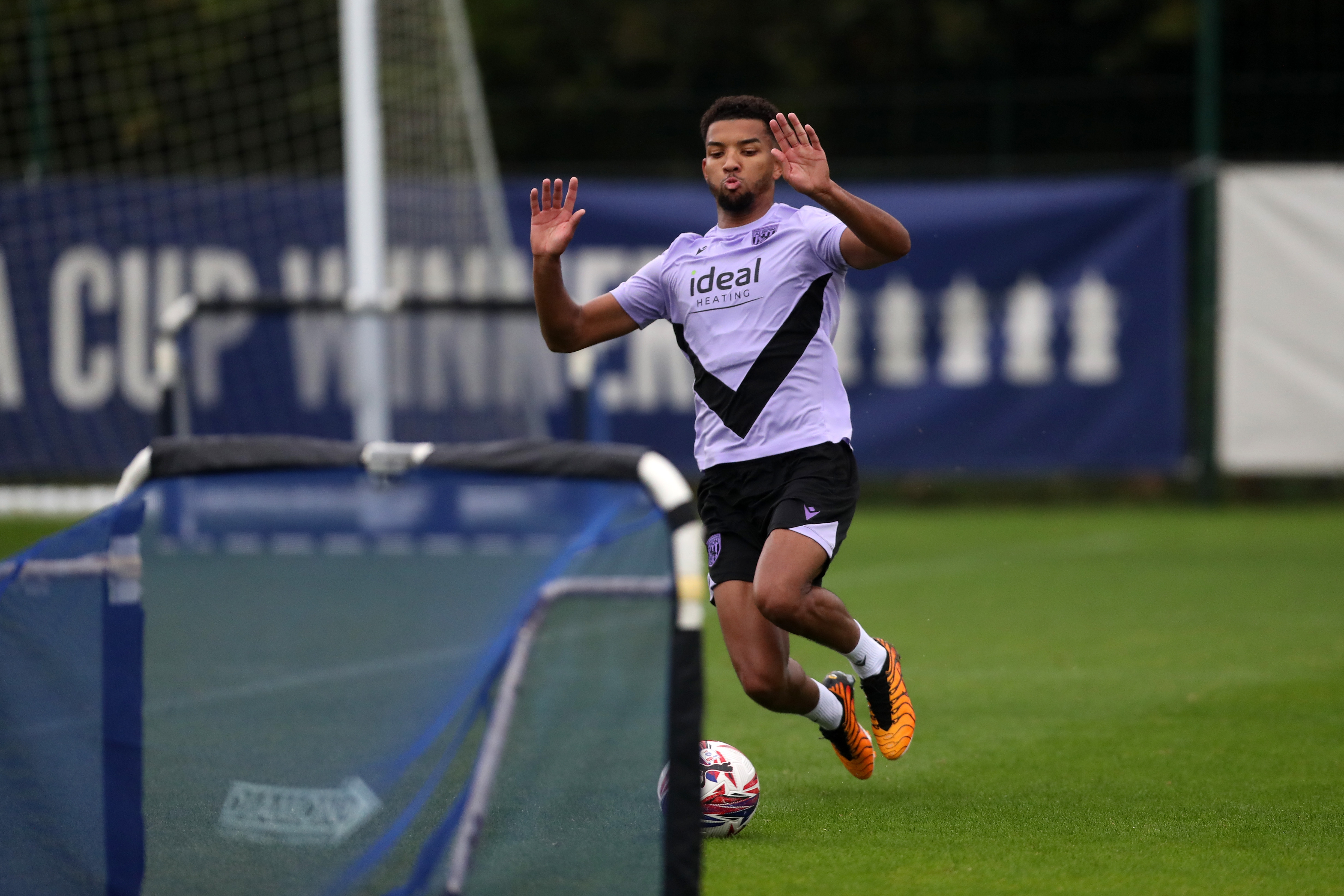 Mason Holgate sliding to reach a ball in front of a mini goal on the training pitch 