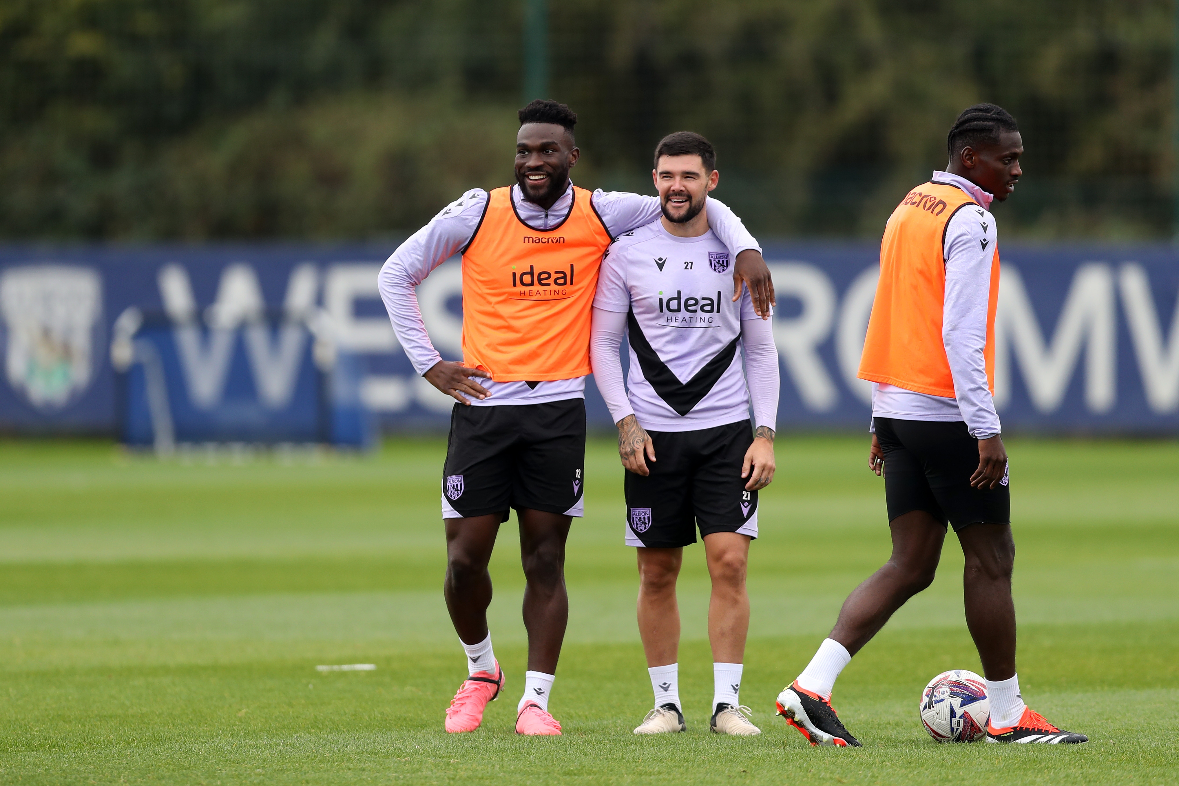 Daryl Dike with his arm around Alex Mowatt during training with both players smiling 