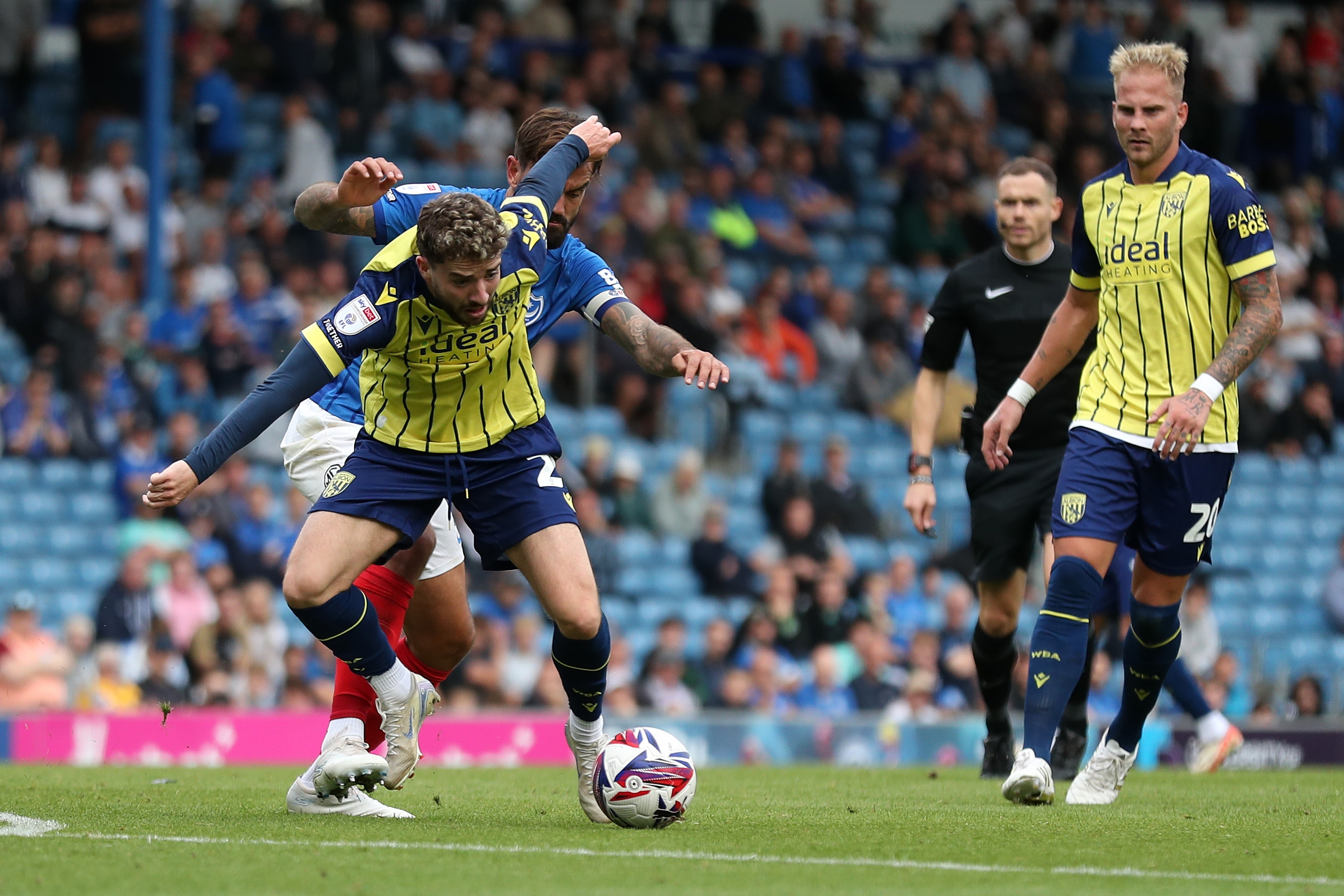 Albion in action against Portsmouth at Fratton Park, in yellow and blue away colours.