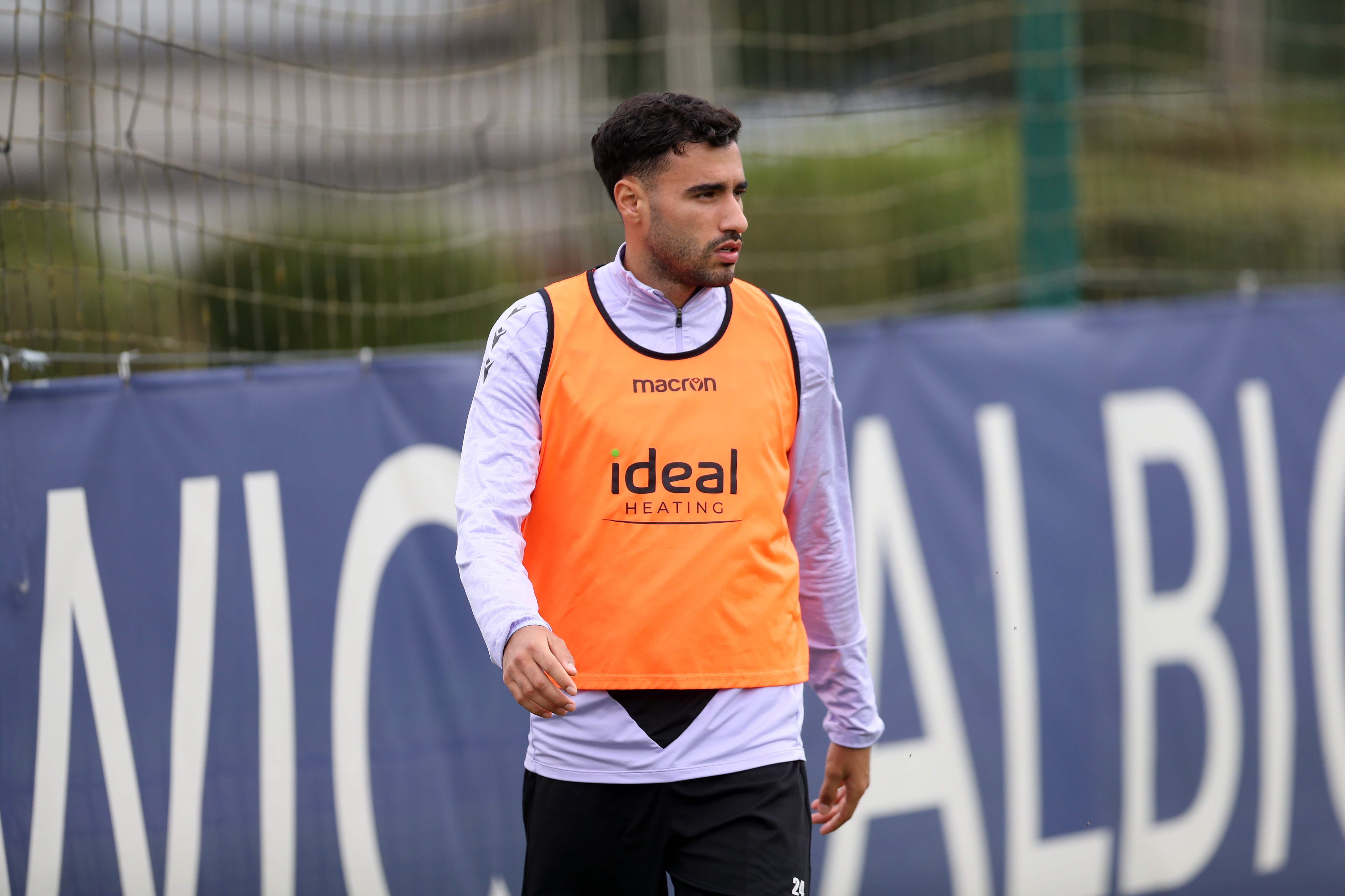 Gianluca Frabotta in a training session looking at the ball while wearing an orange bib