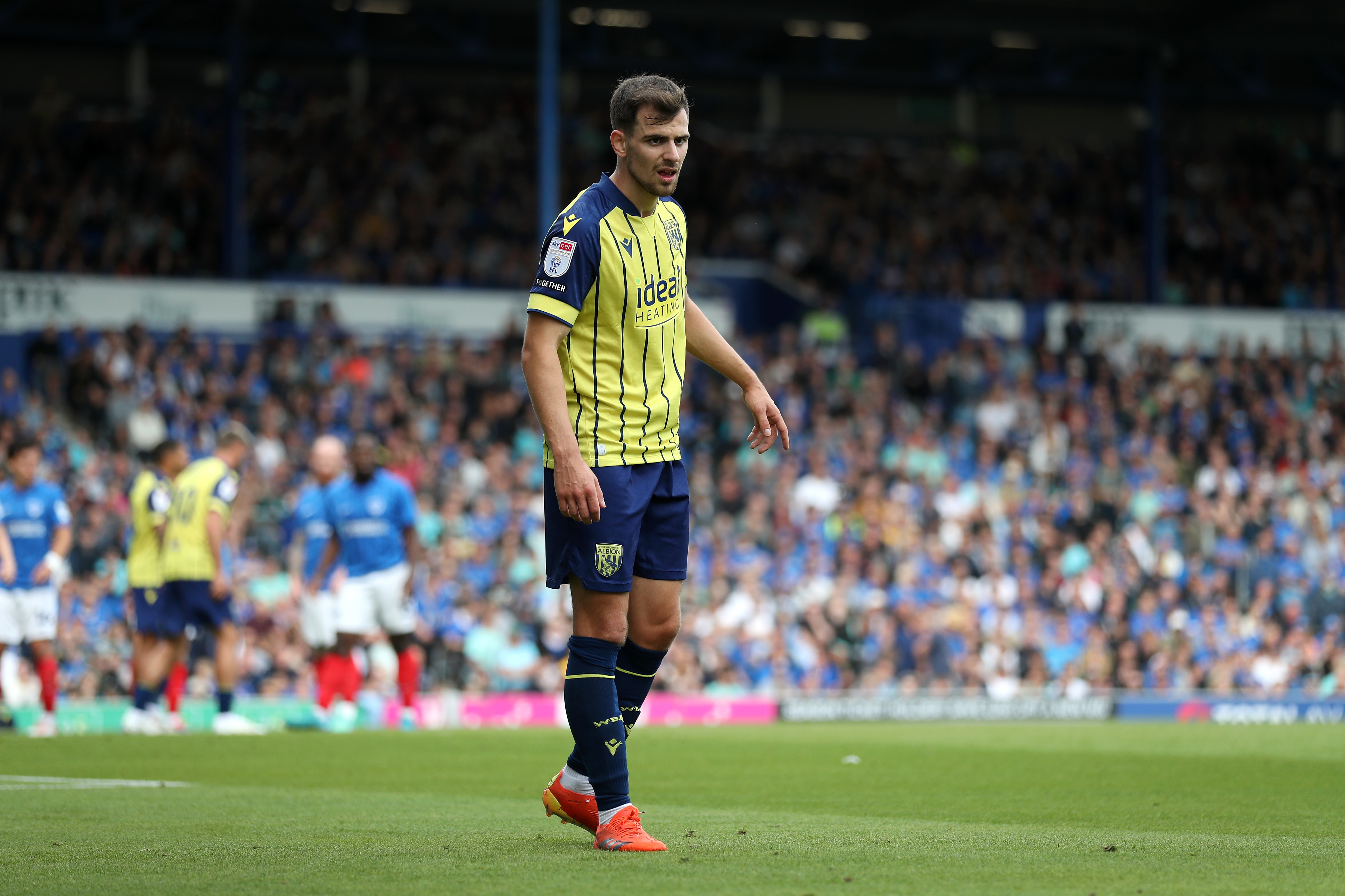 Albion in action against Portsmouth at Fratton Park, in yellow and blue away colours.