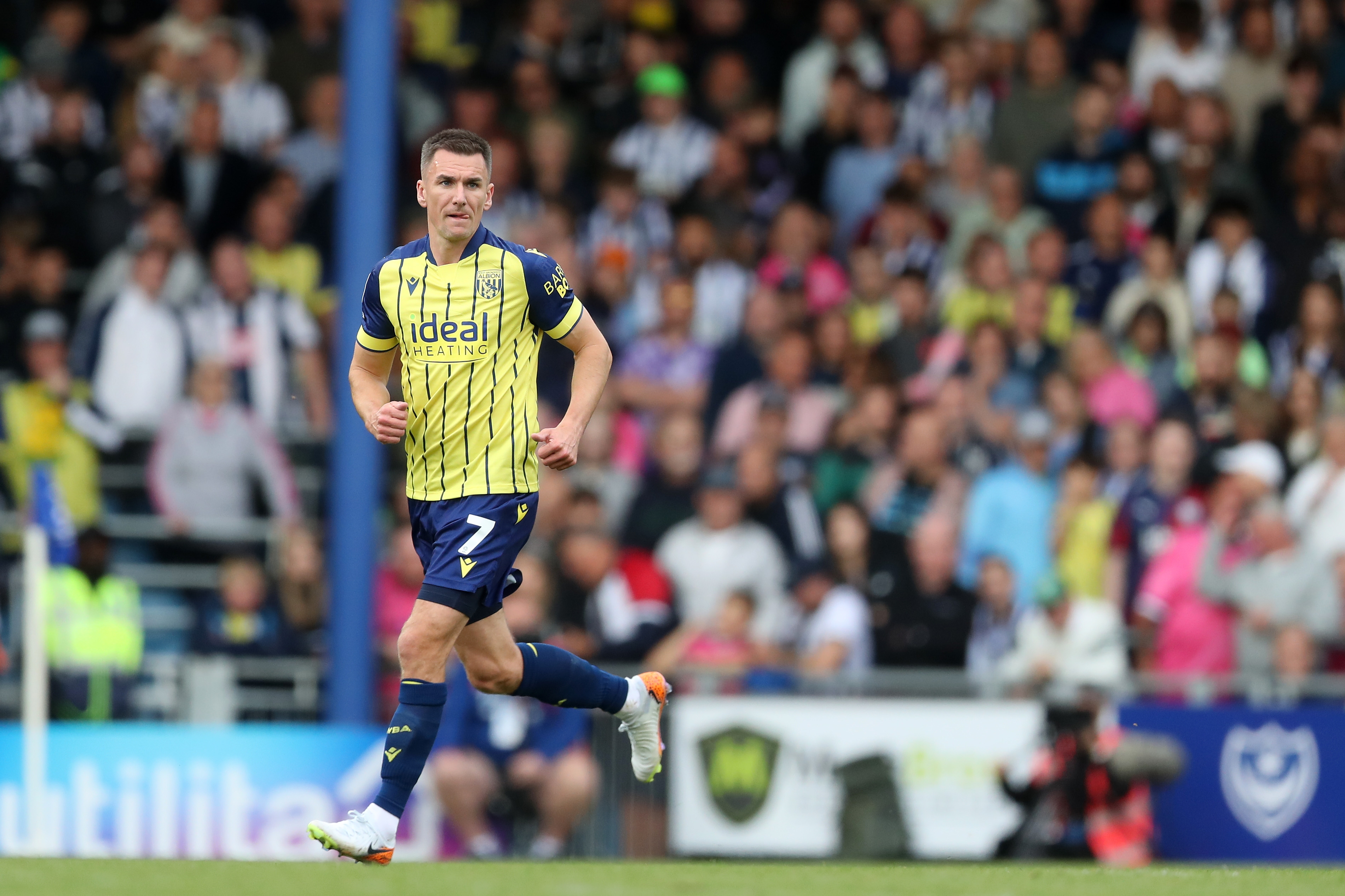 Albion in action against Portsmouth at Fratton Park, in yellow and blue away colours.