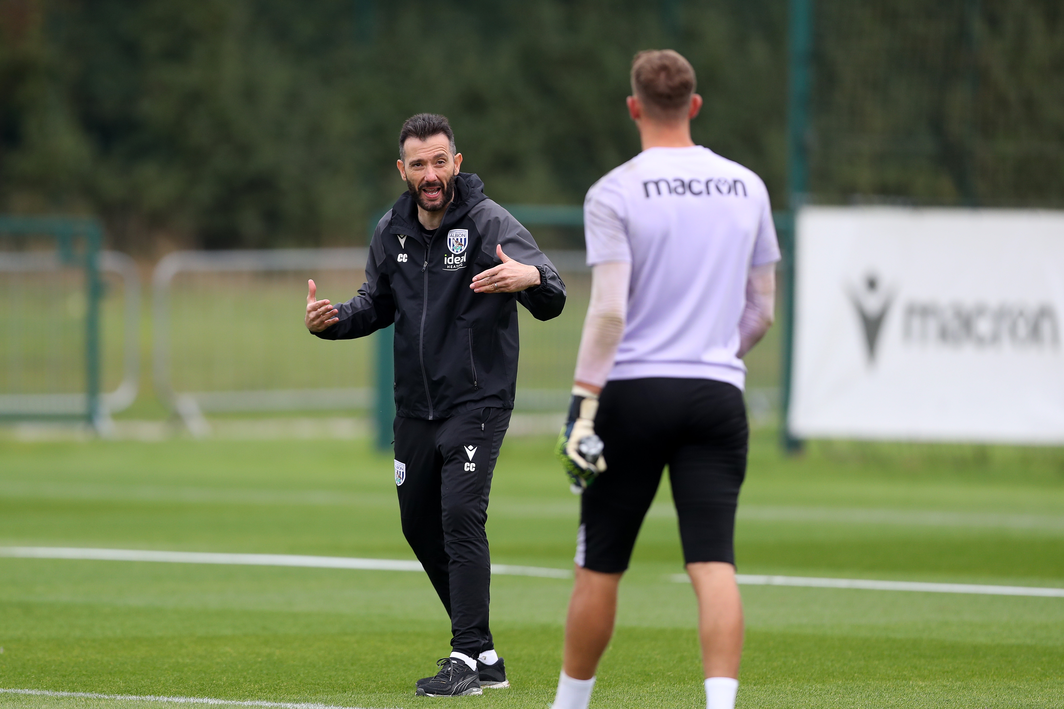 Carlos Corberán delivering instructions to a player on the training pitch 