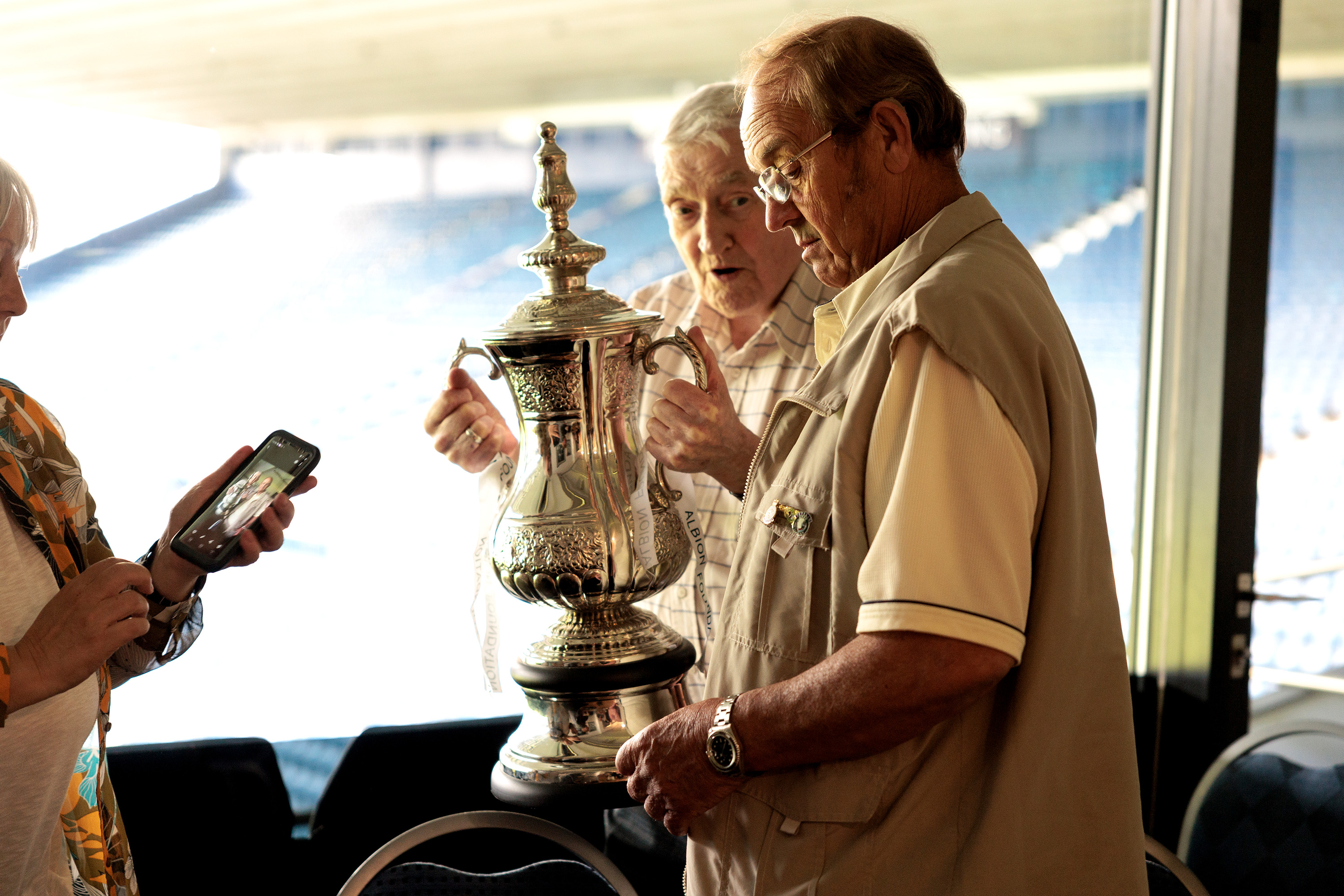 Memories Group participants look at the FA Cup trophy.