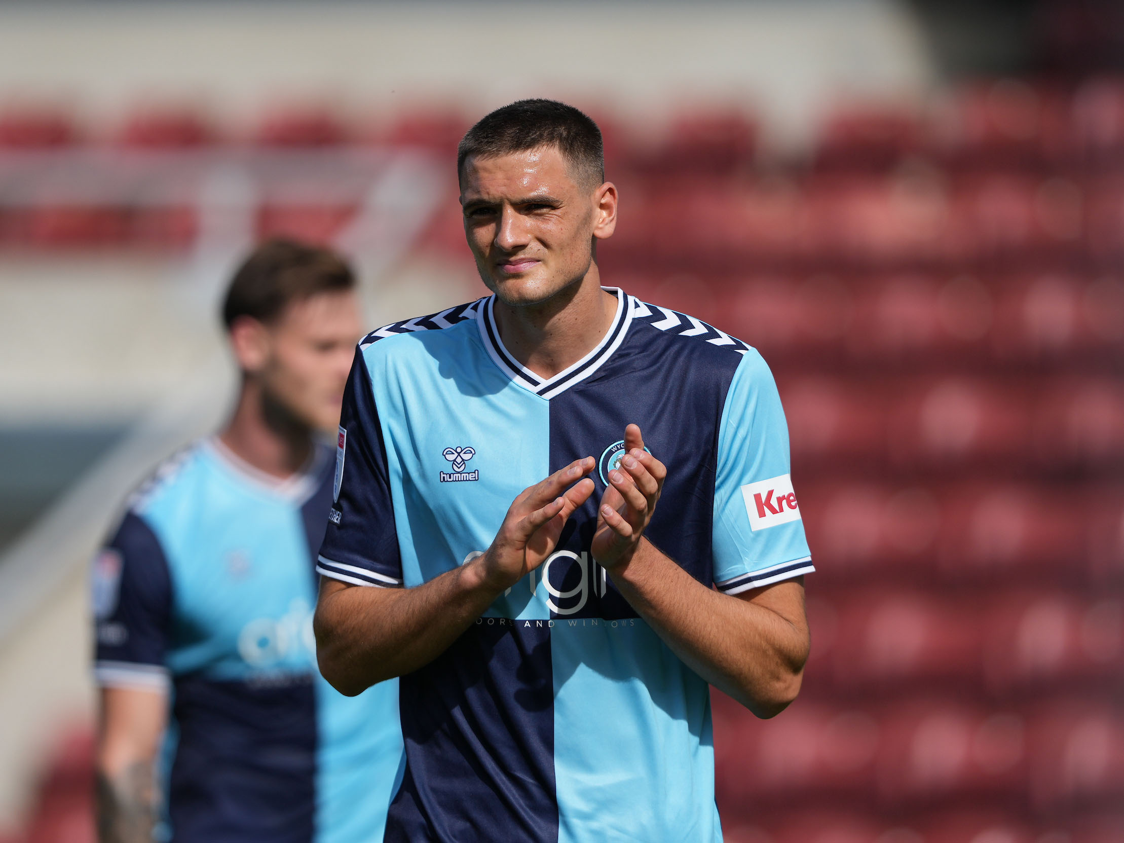 A photo of Caleb Taylor in a Wycombe Wanderers sky blue and navy blue home kit