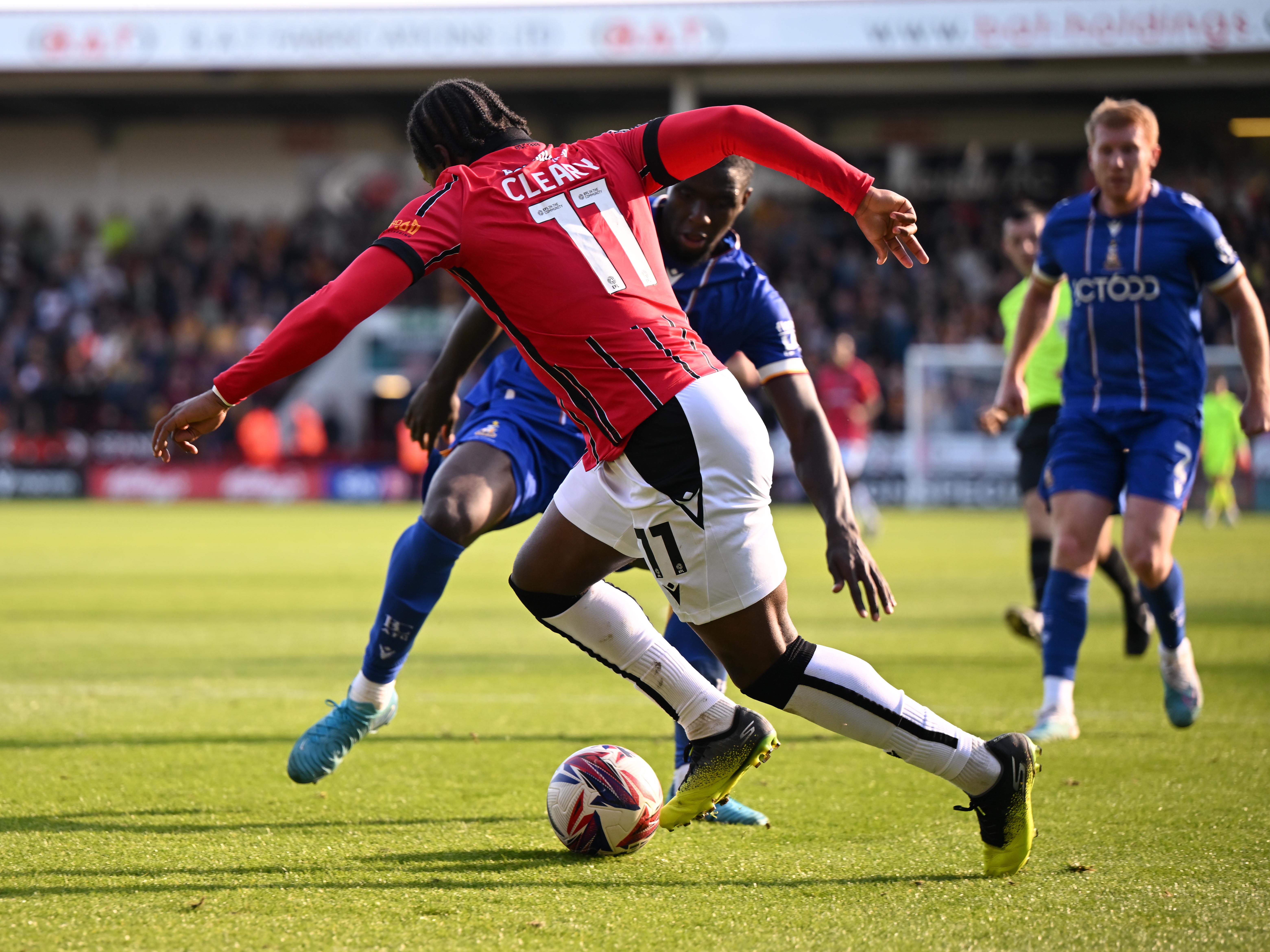 A photo of Reyes Cleary running with the ball in the red home kit of loan club Walsall during a League Two match v Bradford City