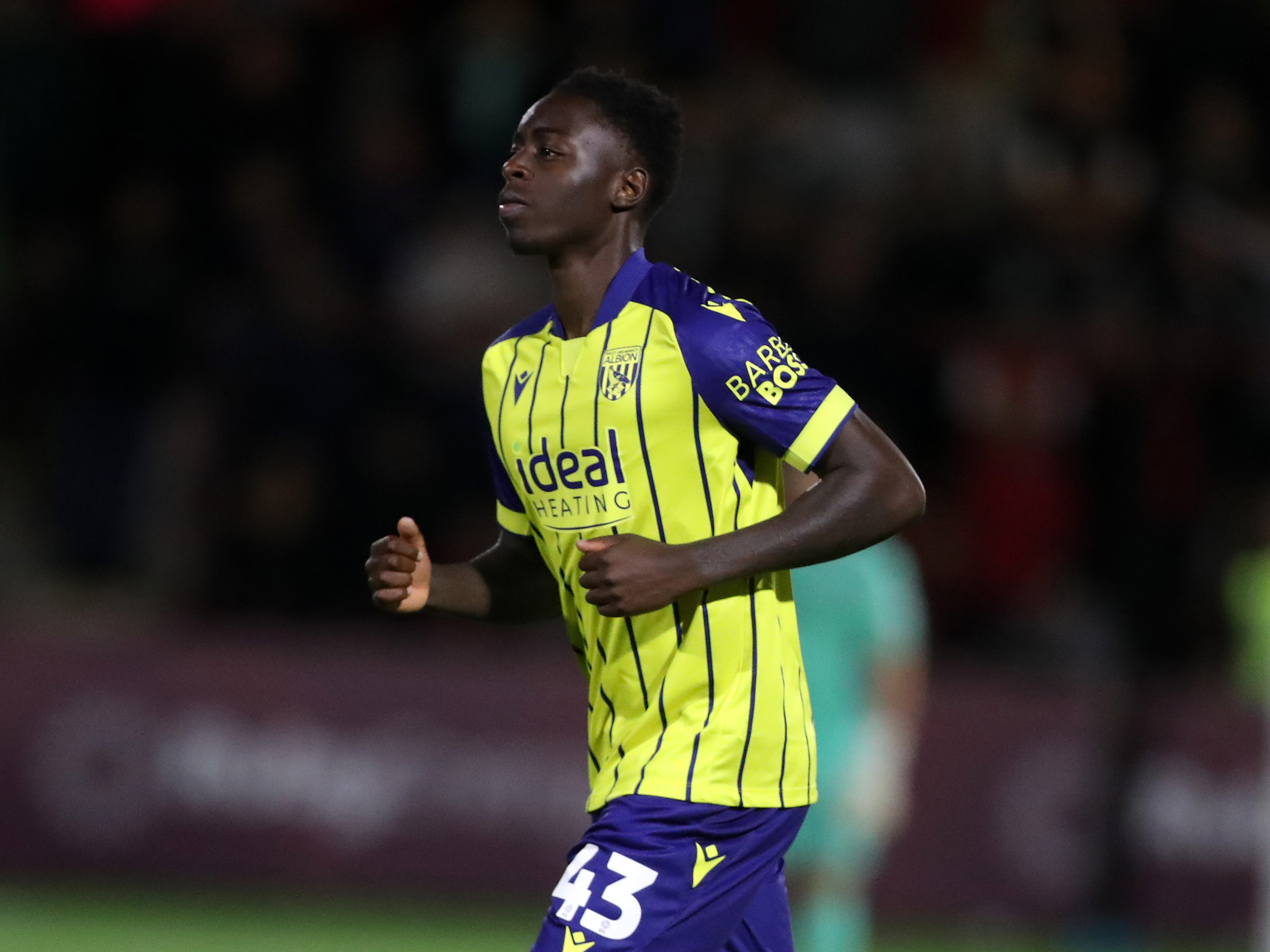 A photo of Eseosa Sule in the yellow and blue 24/25 kit playing against Fleetwood in the Carabao Cup