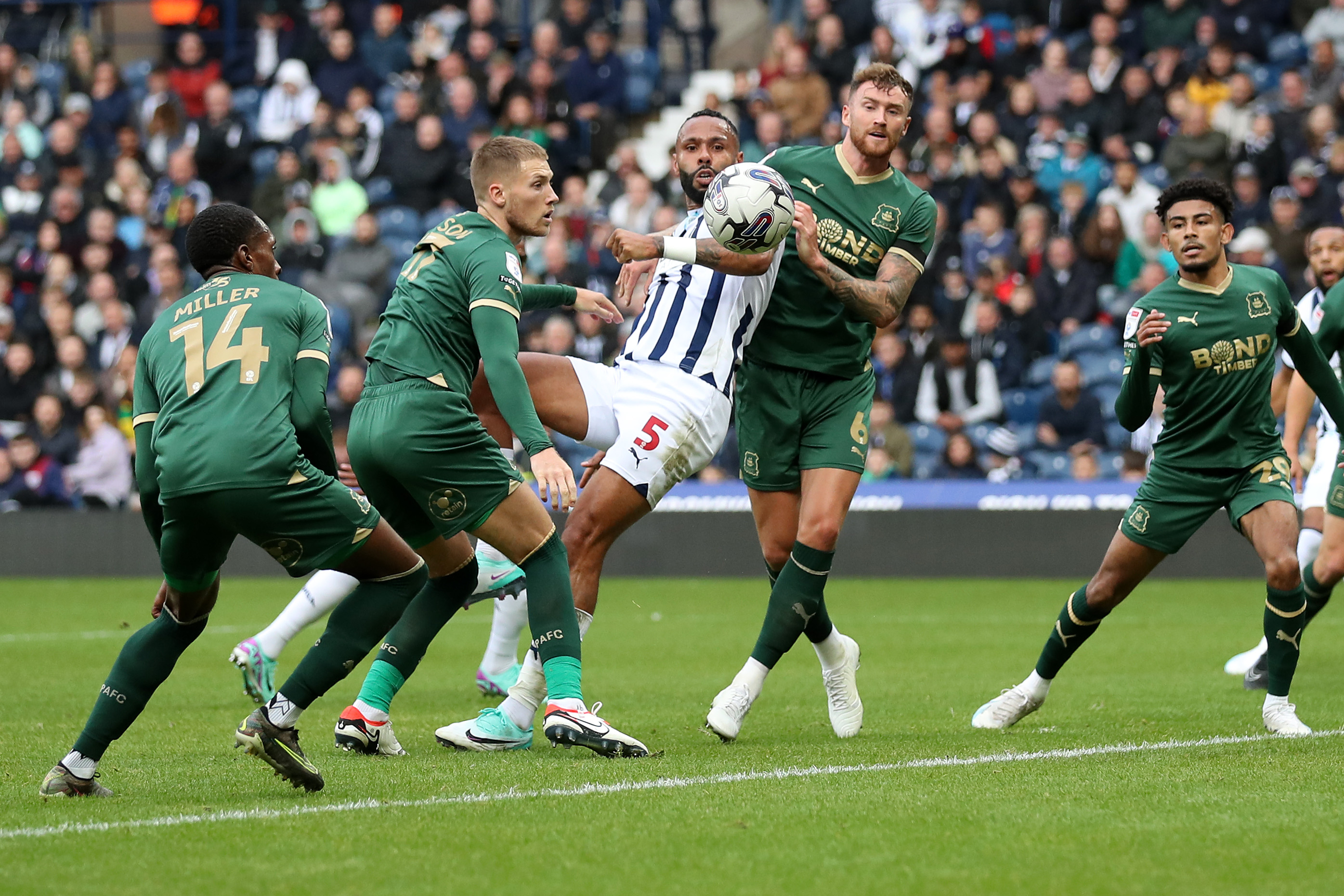 Kyle Bartley fights for the ball with several Plymouth defenders 