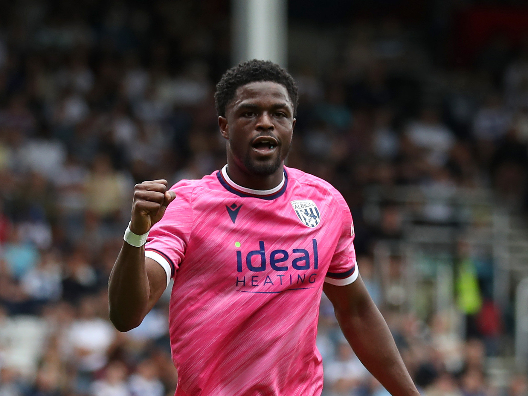 Josh Maja celebrates scoring for Albion at QPR while wearing the pink kit 