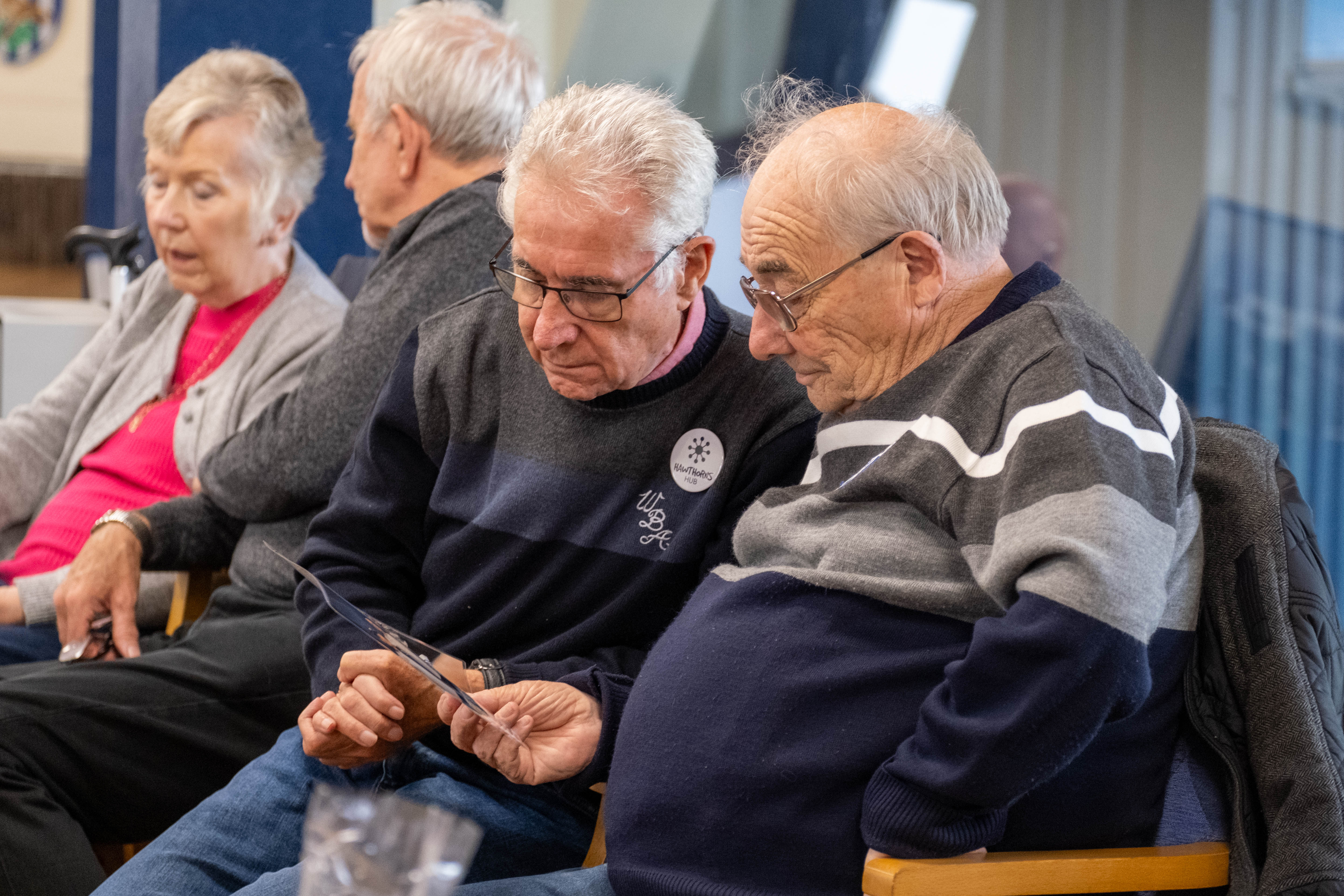 Two Memories Group attendees look at a photo together.