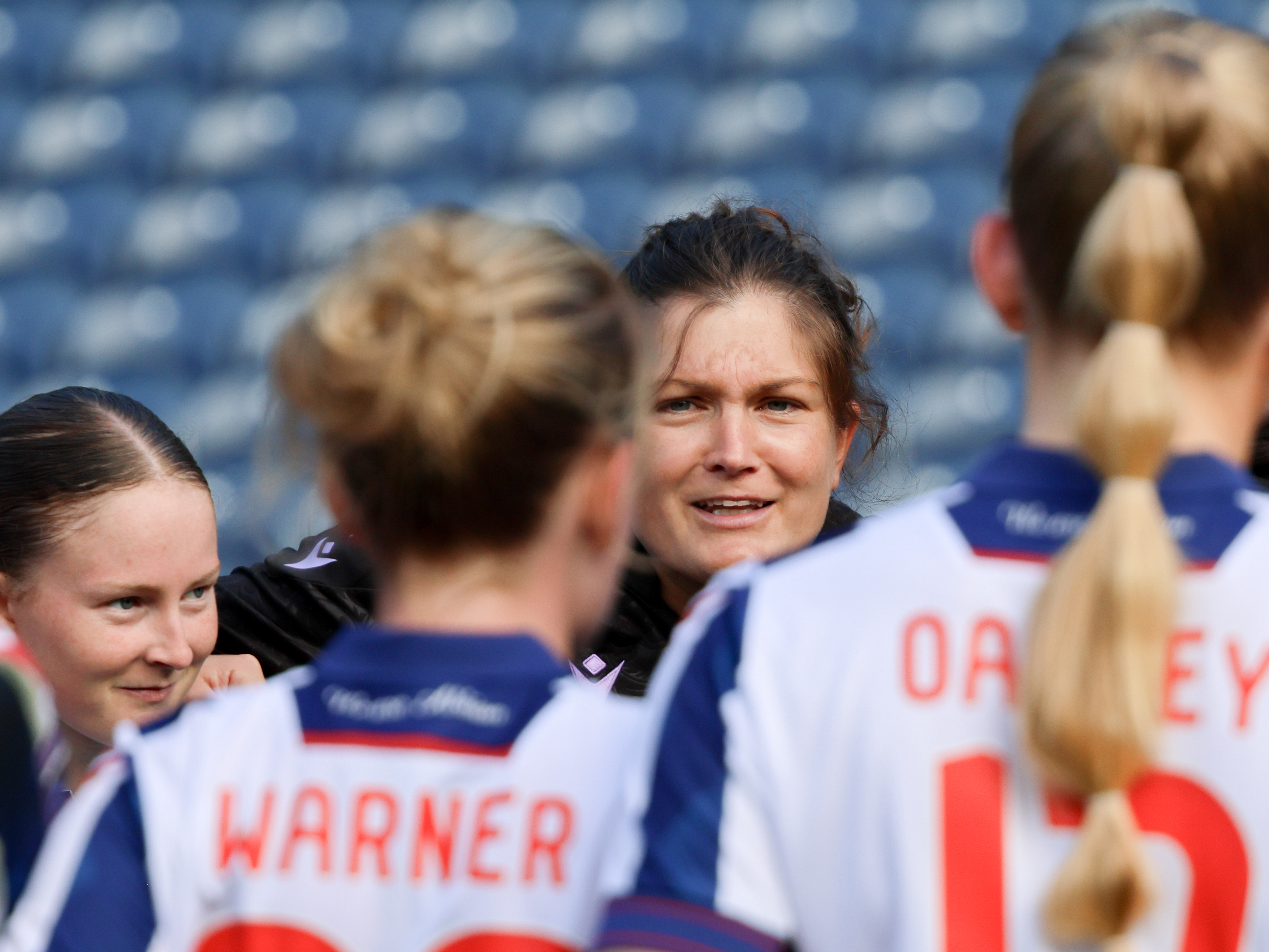 An image of Siobhan Hodgetts-Still and Liv Rabjohn as part of a team huddle