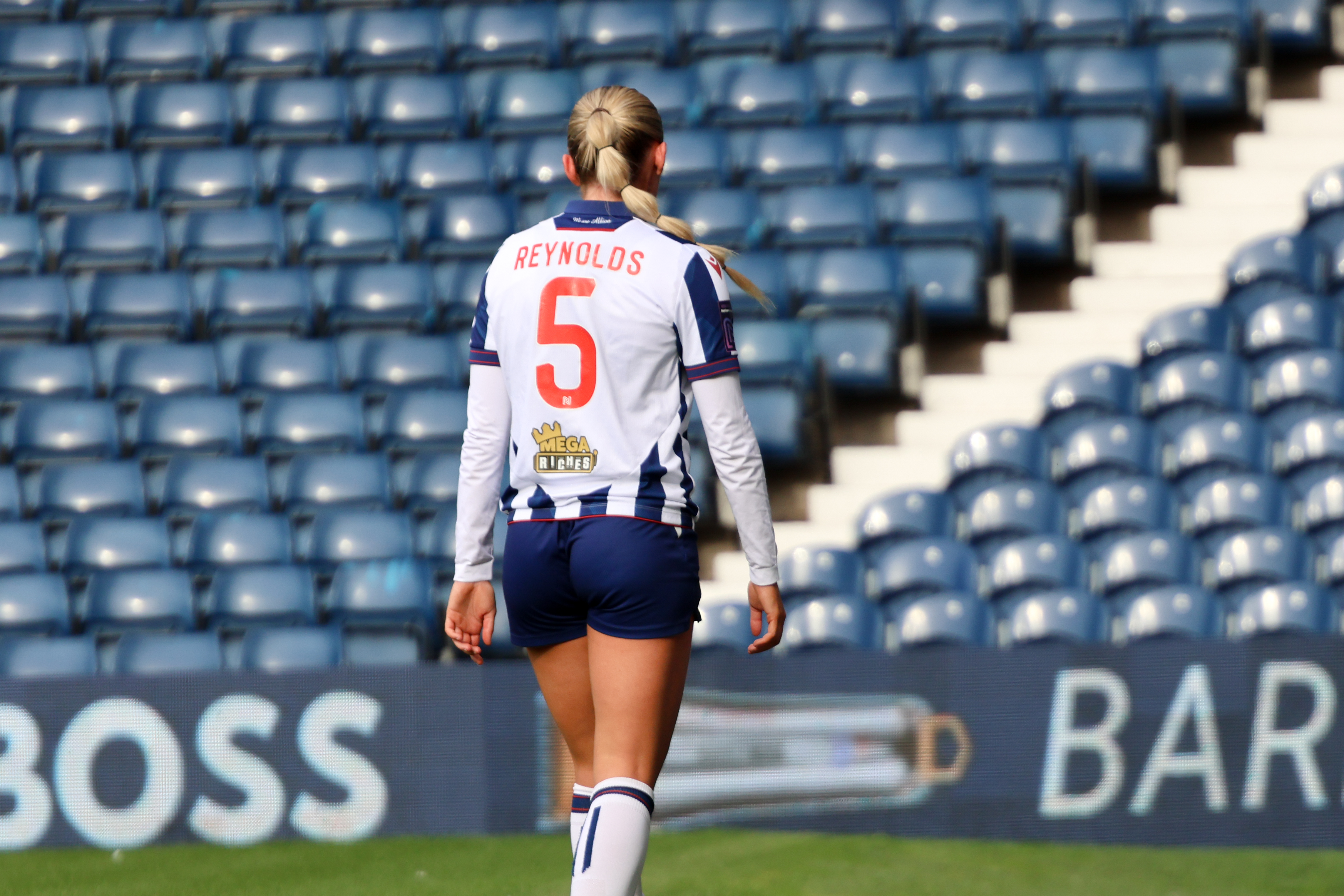 Taylor Reynolds facing away from camera with her name and NO.5 on the back of her shirt during a game at The Hawthorns 