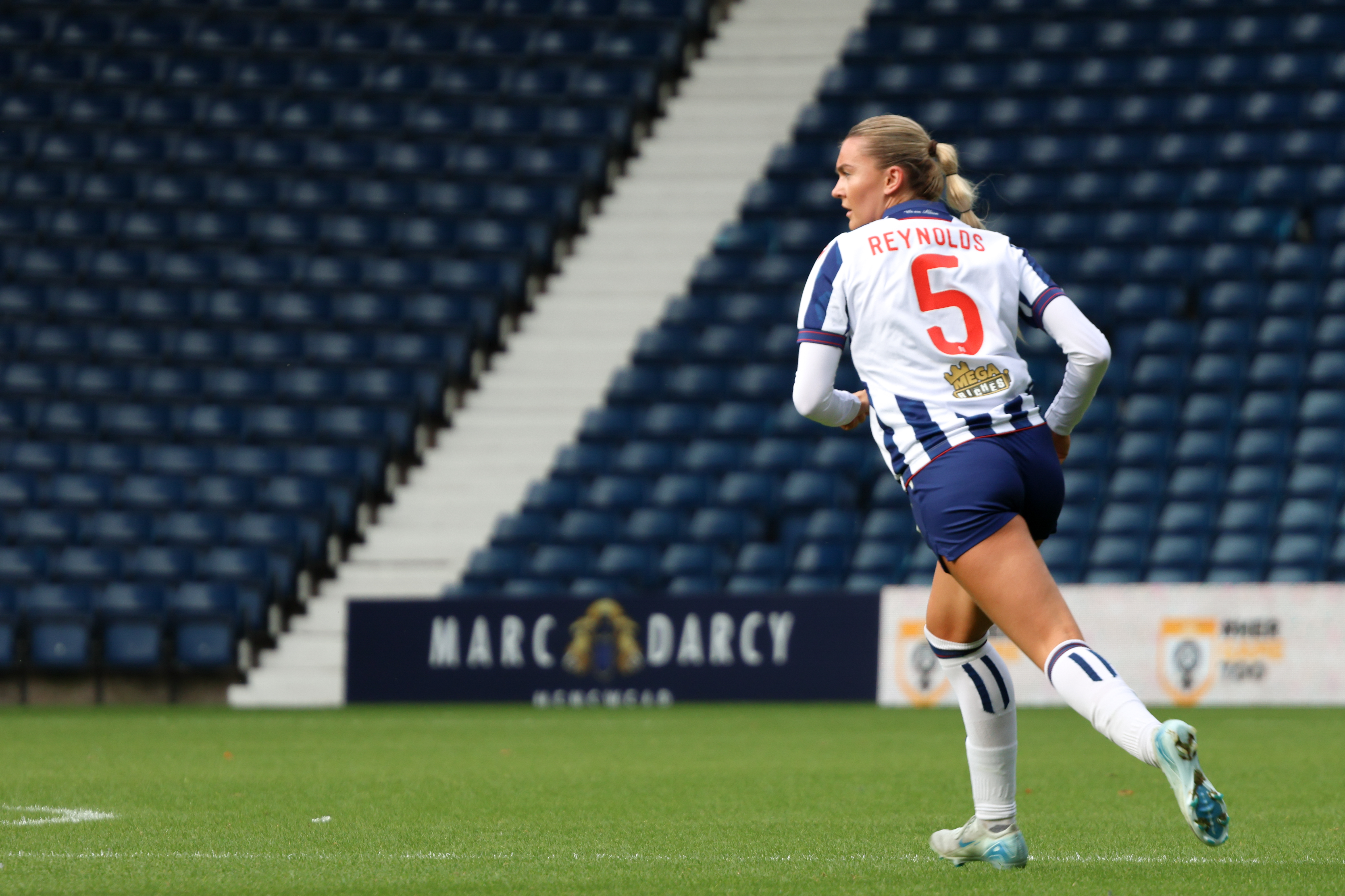 Taylor Reynolds running forward wearing the home kit during a game at The Hawthorns 