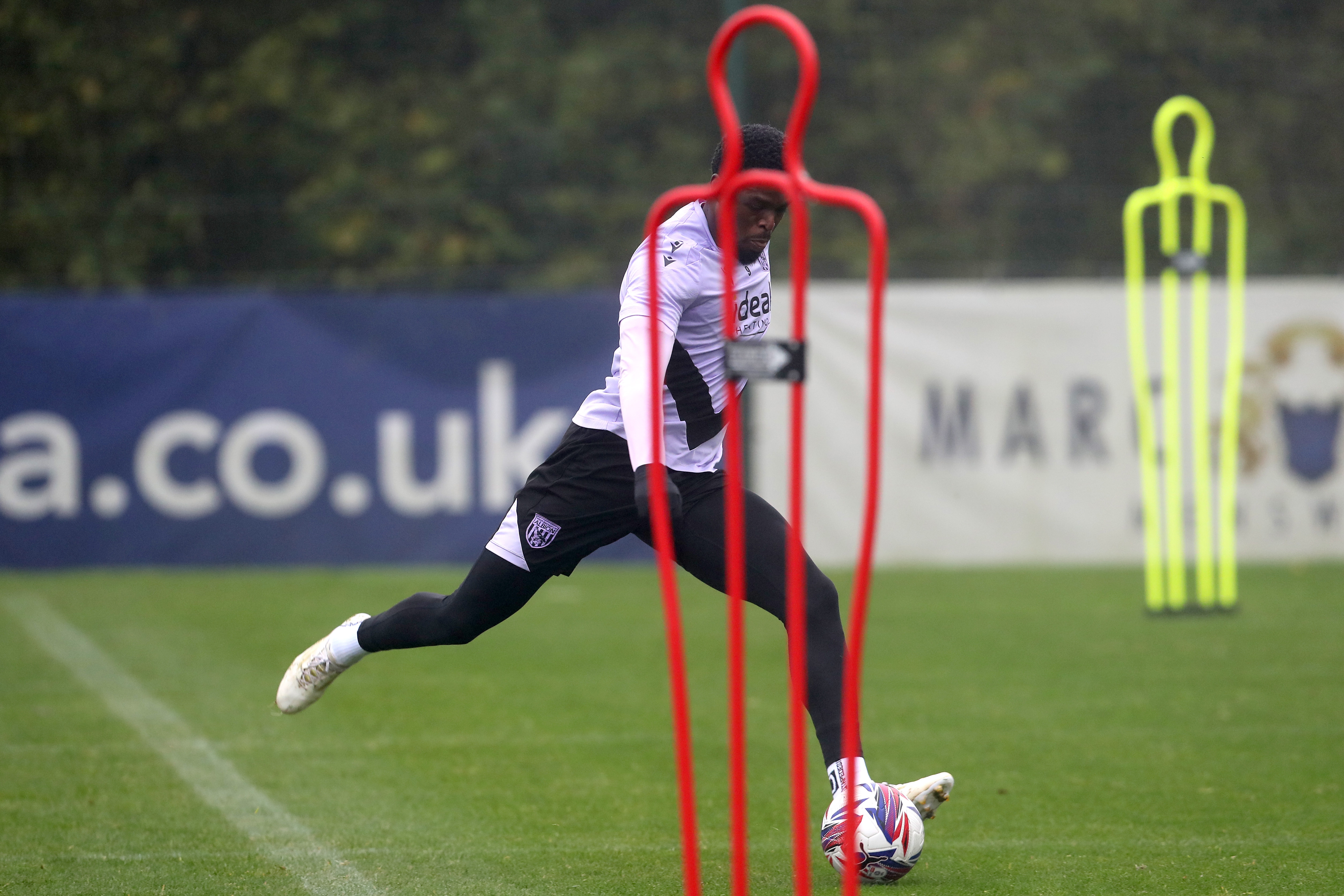 Josh Maja striking the ball behind a mannequin during a training session 