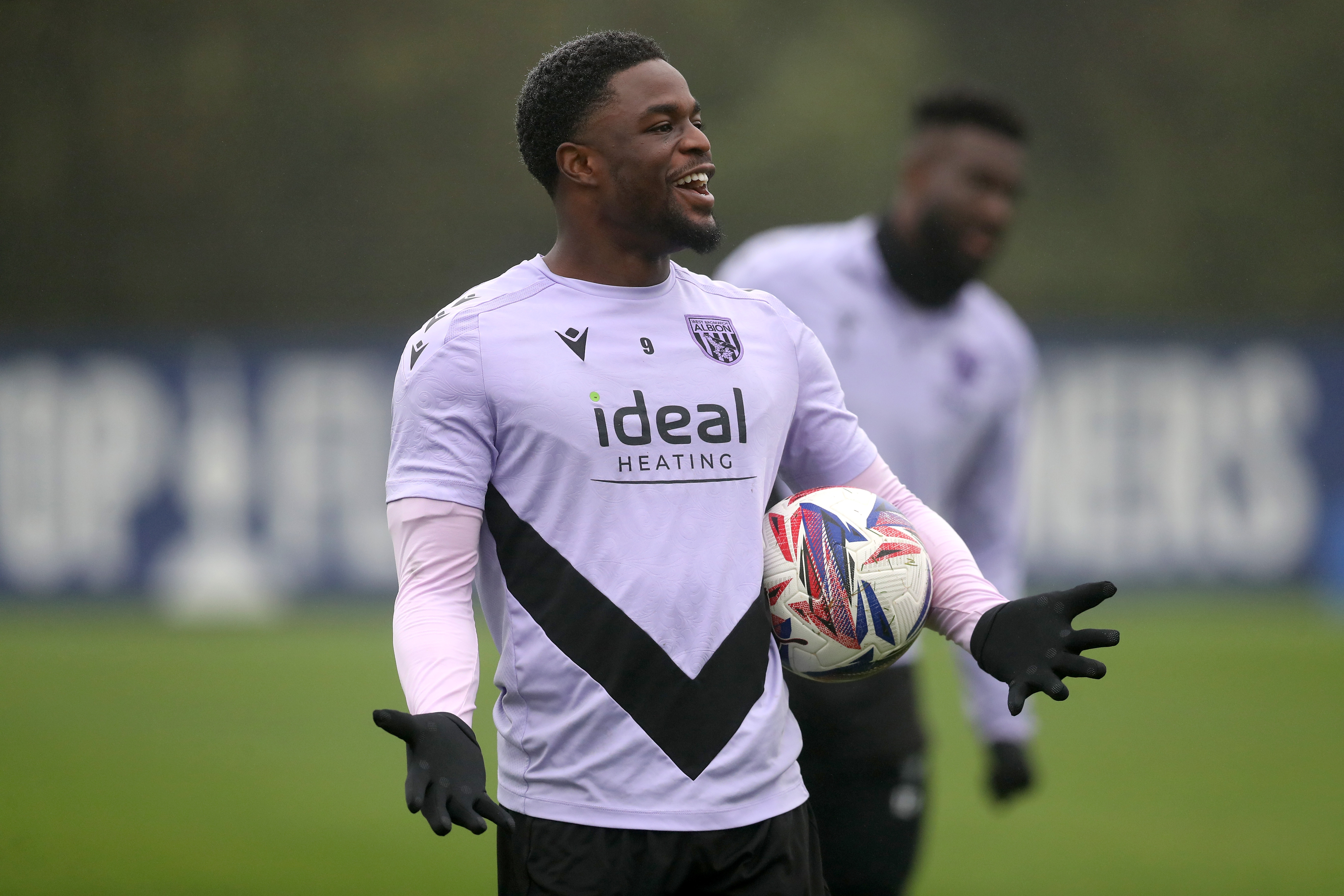 Josh Maja laughing during a training session holding his arms out with a ball 