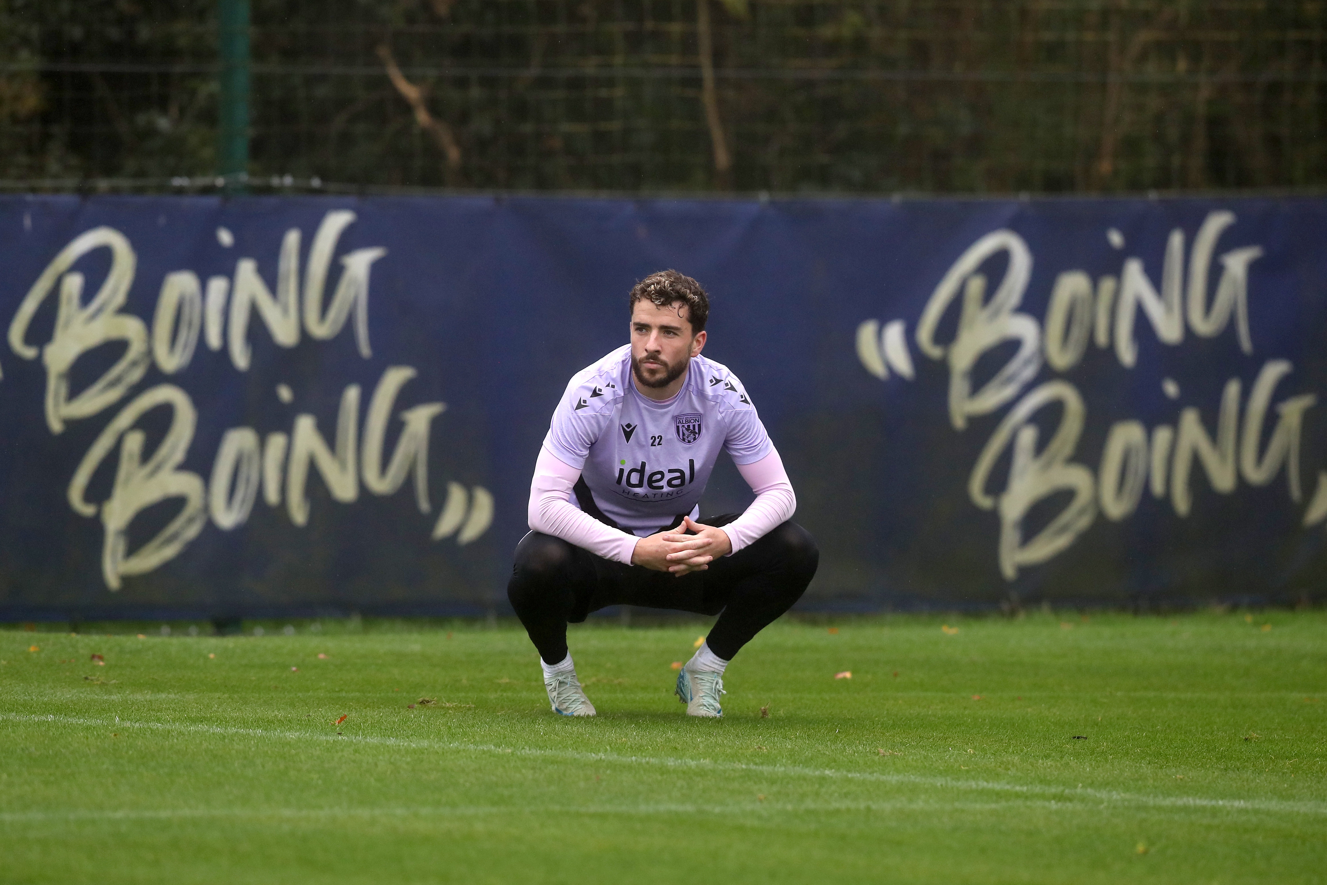 Mikey Johnston crouched down watching training 