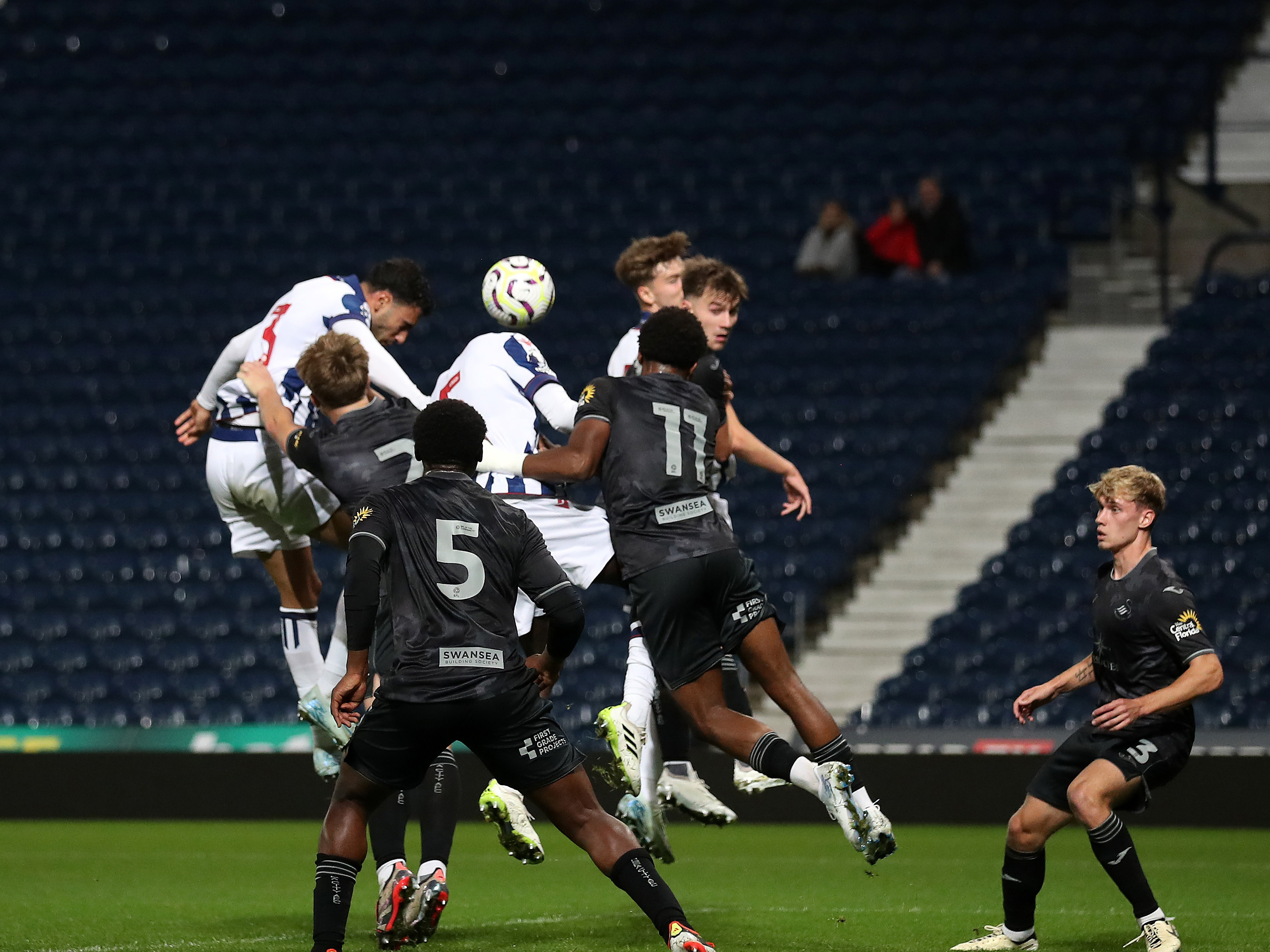 Several players jump for the ball in the PL Cup match between Albion and Swansea 