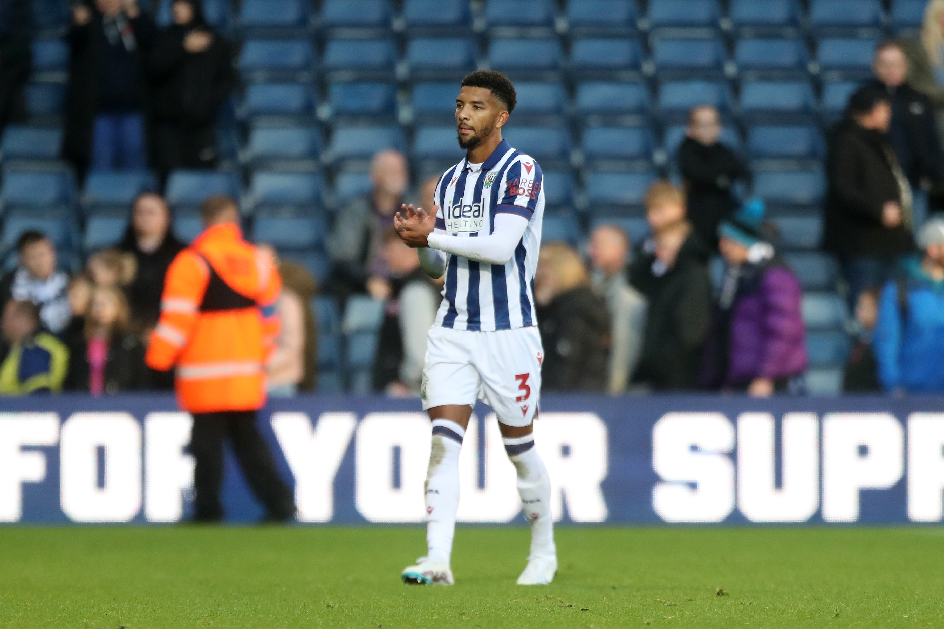 Mason Holgate applauding Albion fans at The Hawthorns while wearing the home kit 