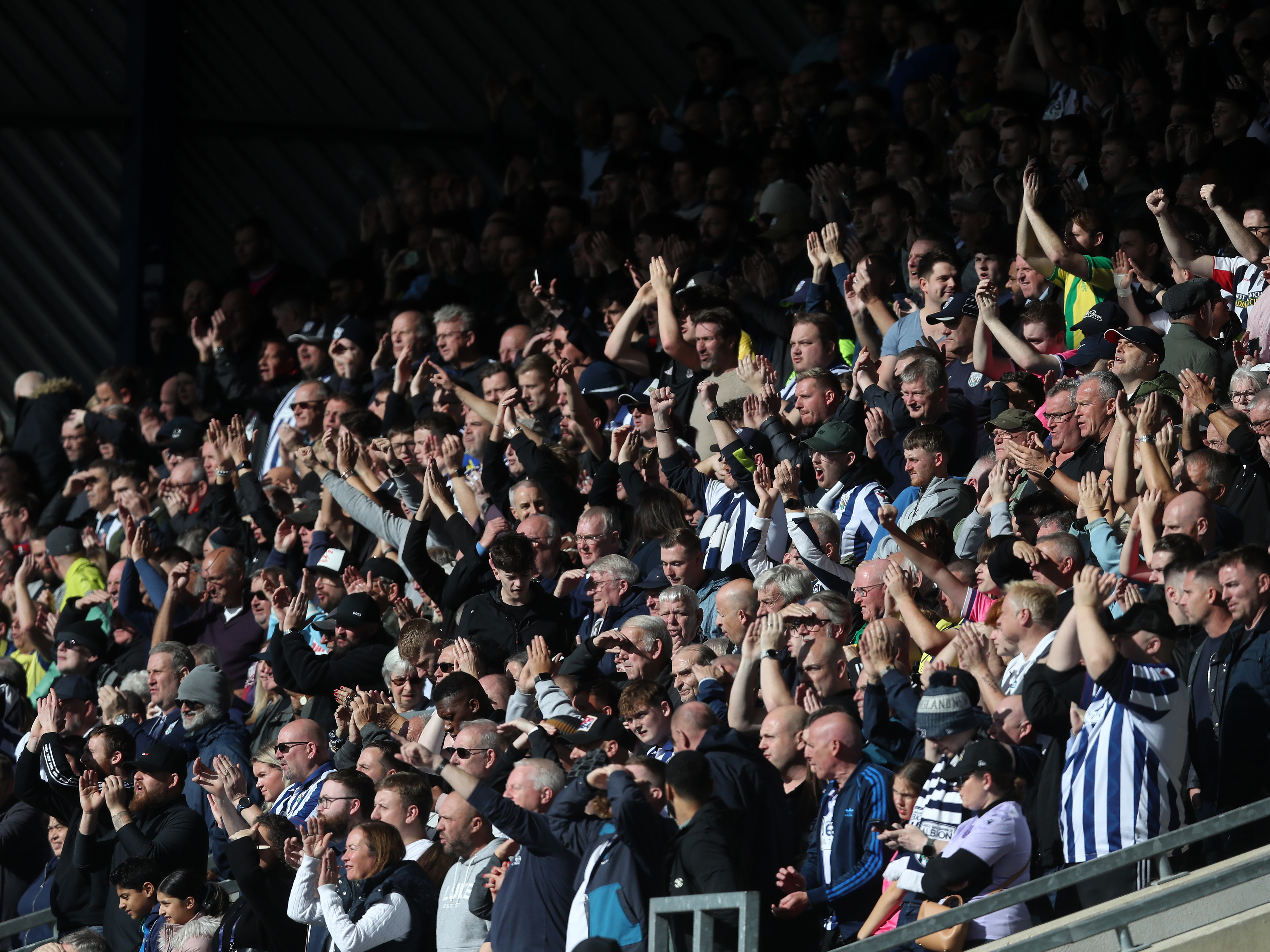 An image of Albion supporters applauding their team from the away end at Oxford