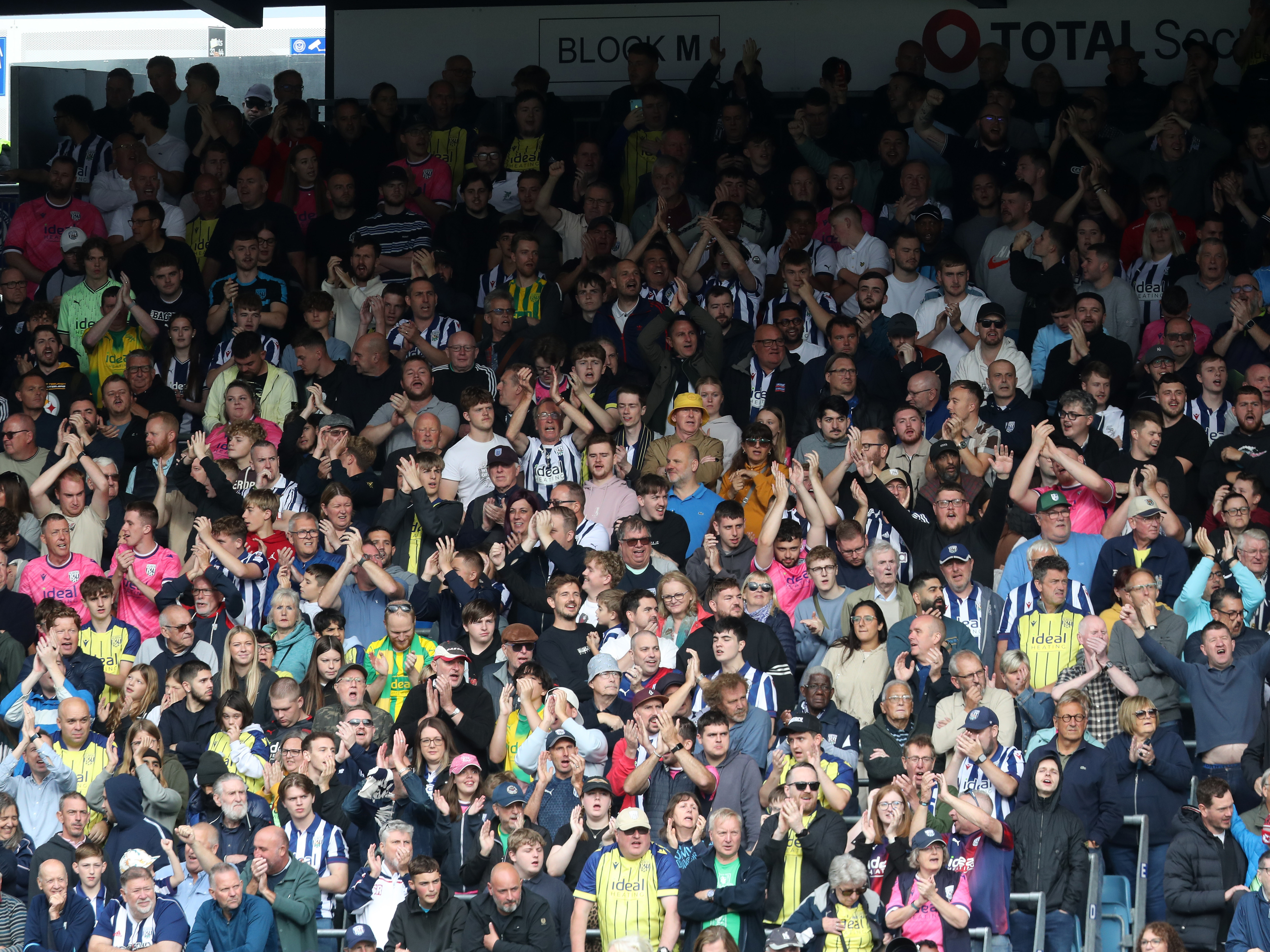 An image of Albion supporters cheering on their team from Portsmouth's away end