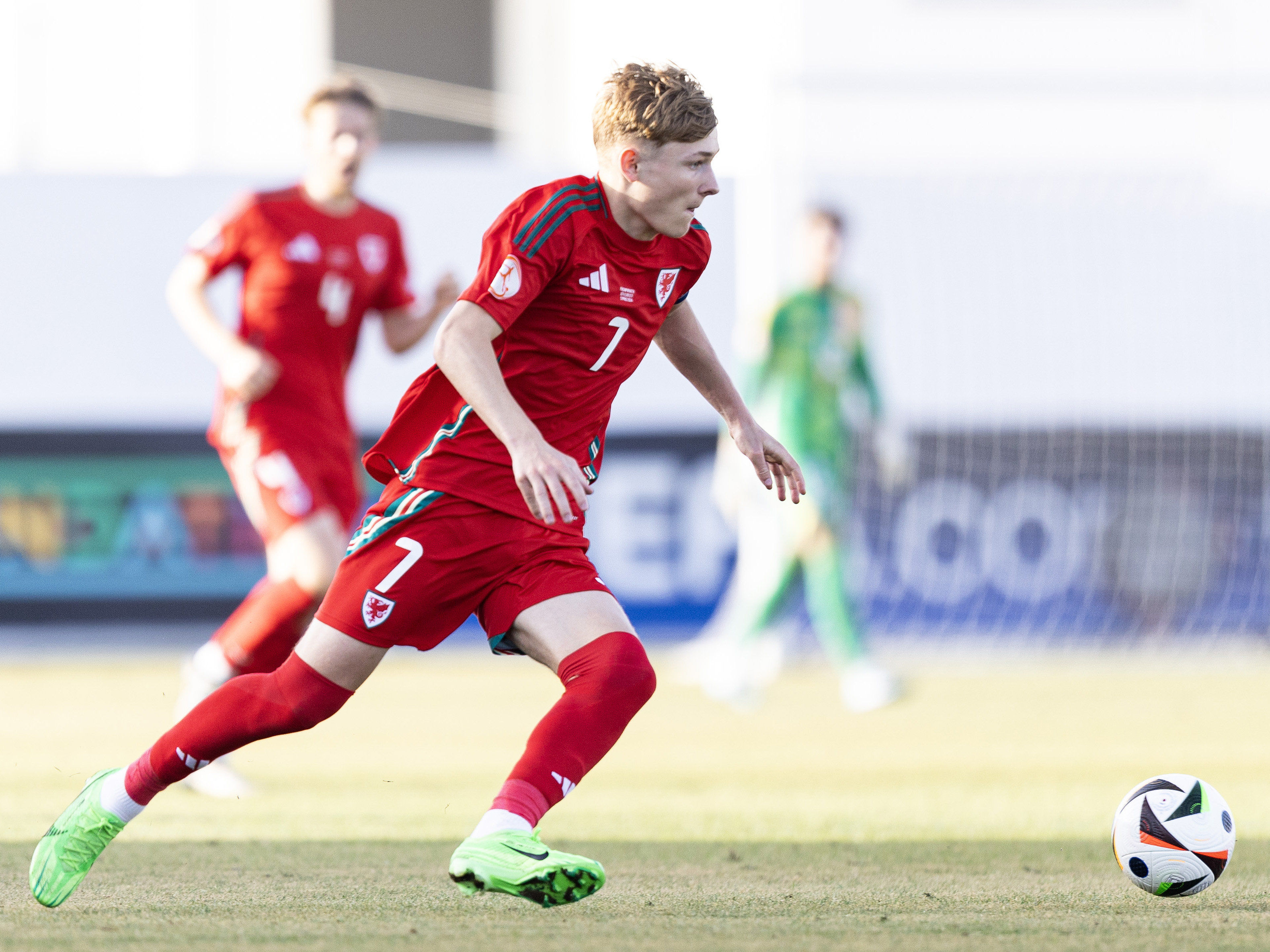 A photo of youngster Ollie Bostock in action for Wales, in the red home kit of his nation