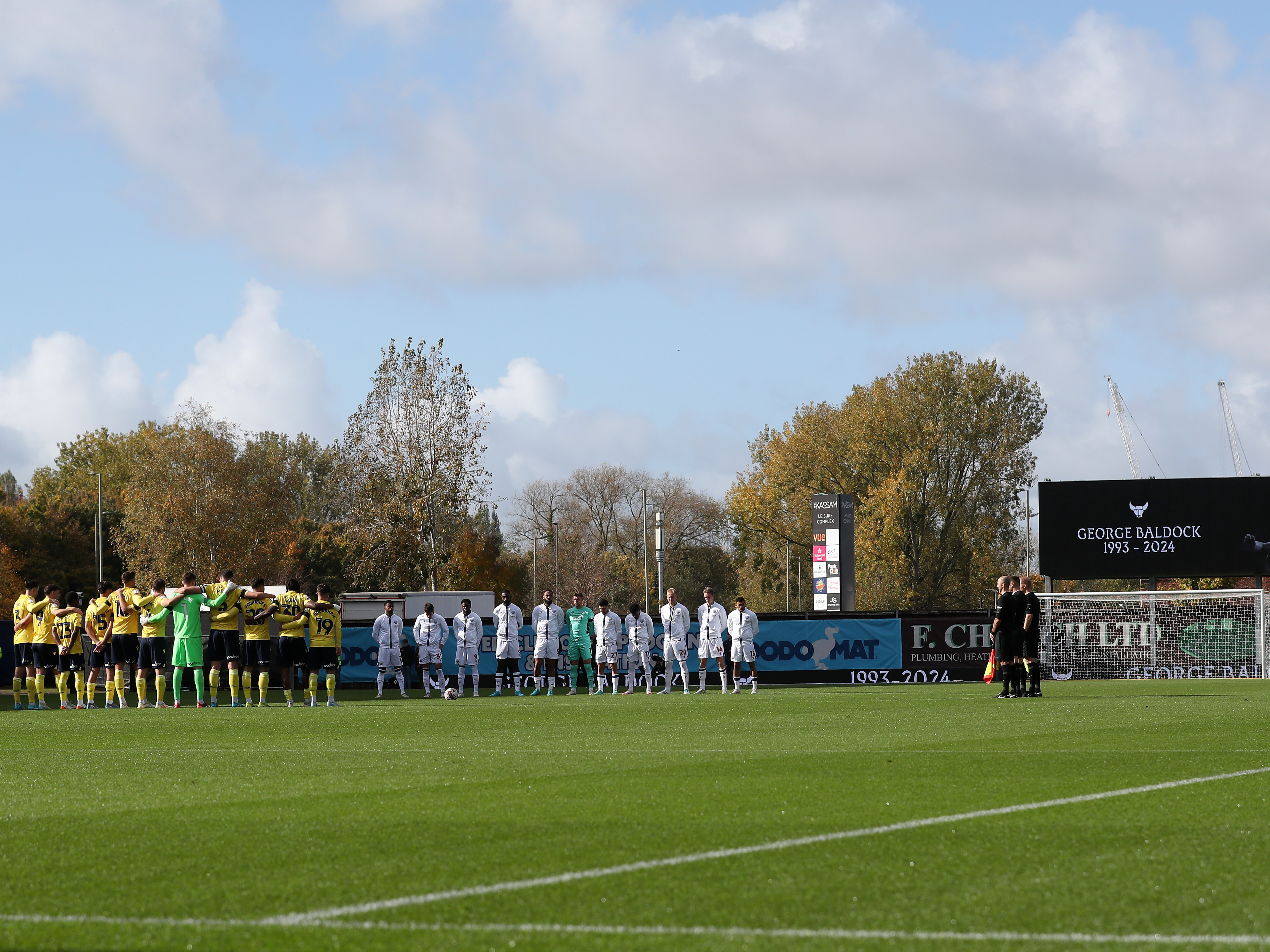 An image of Albion and Oxford lined up around the centre circle during a period of silence for George Baldock