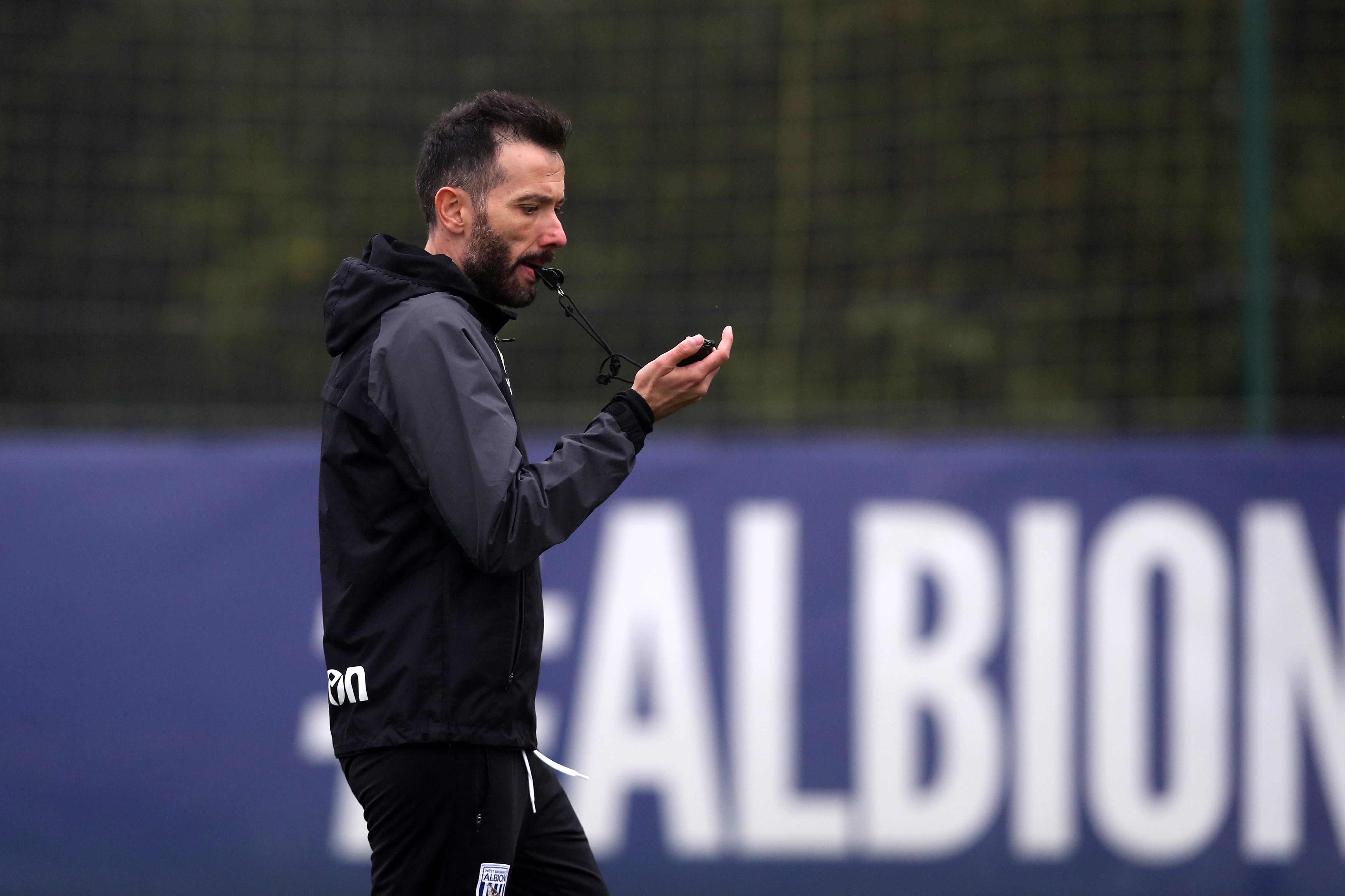 Carlos Corberán blowing a whistle during a training session 