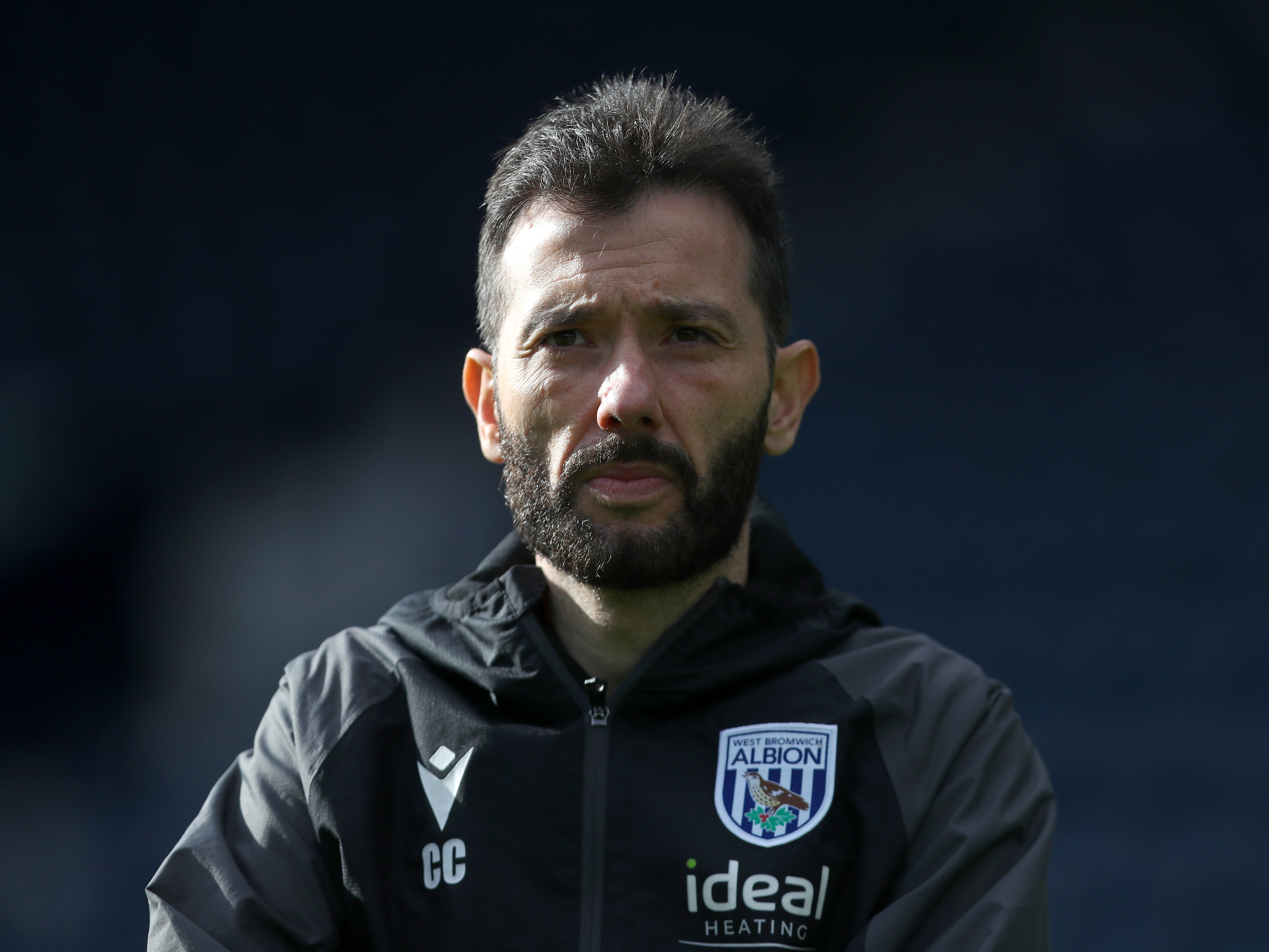 Carlos Corberán looking forward during a training session in a black Albion coat 