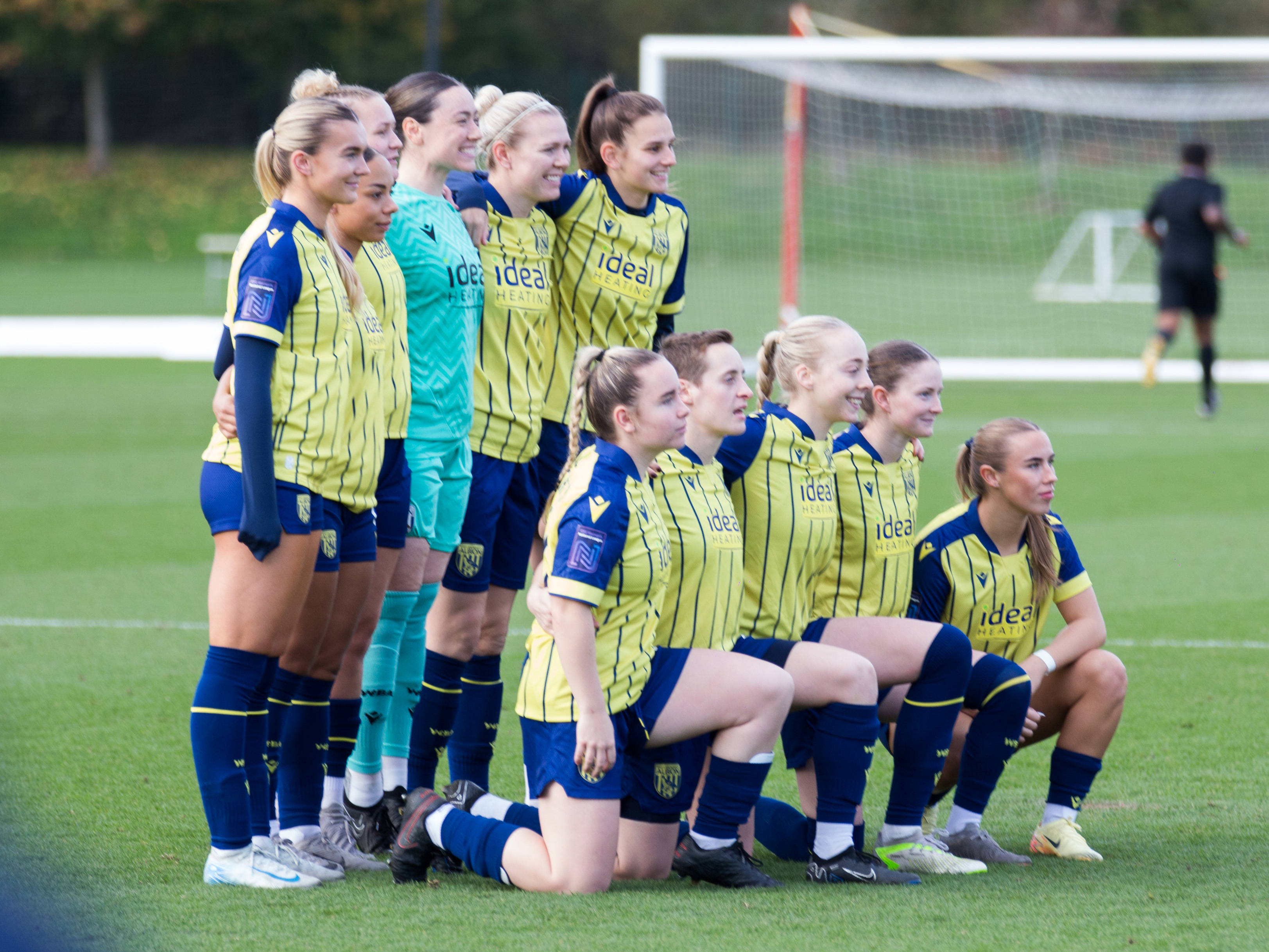 A team photo of Albion Women before their game at Stoke with the players wearing the yellow and blue away kit 