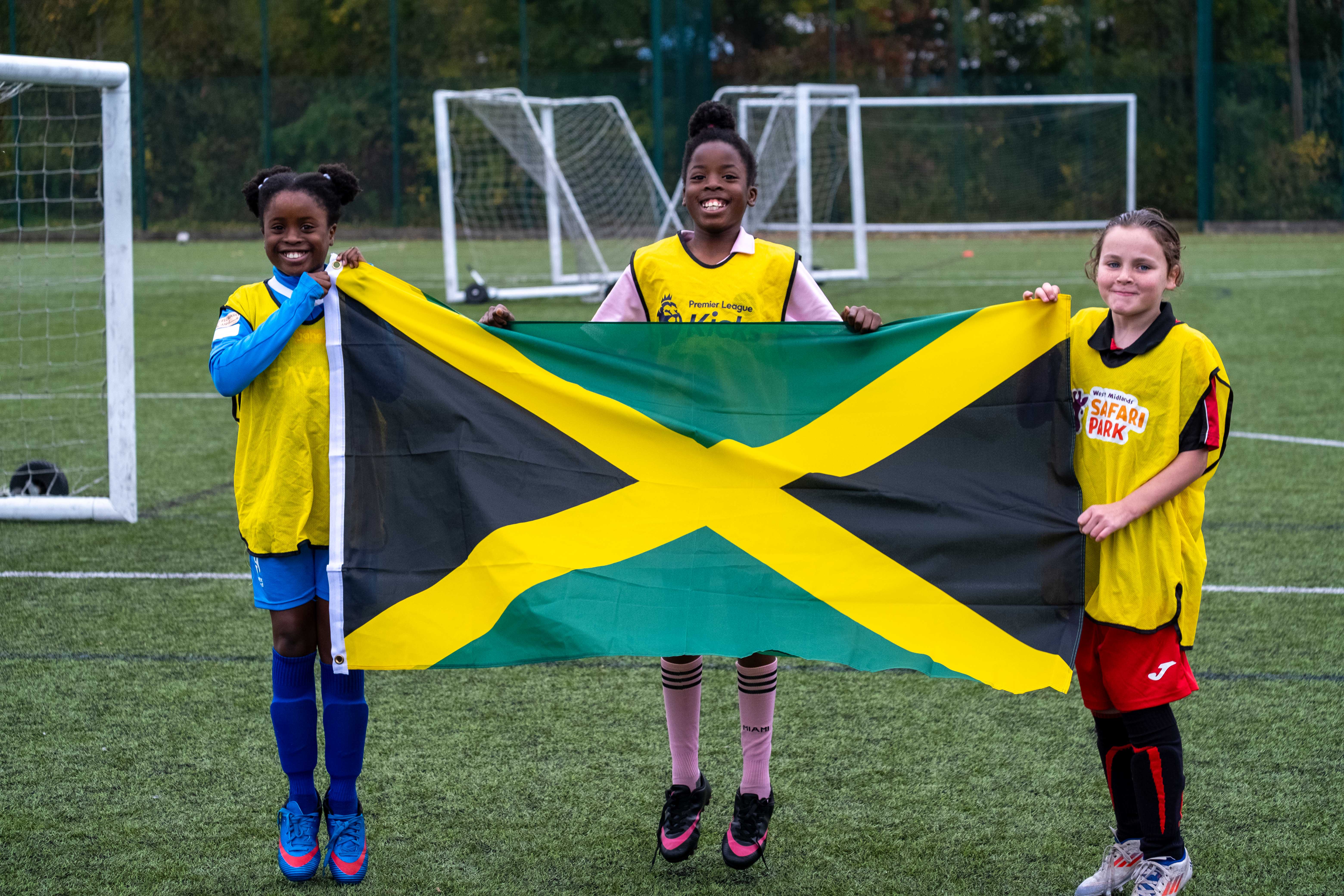 Three PL Kicks participants with the Jamaica flag.