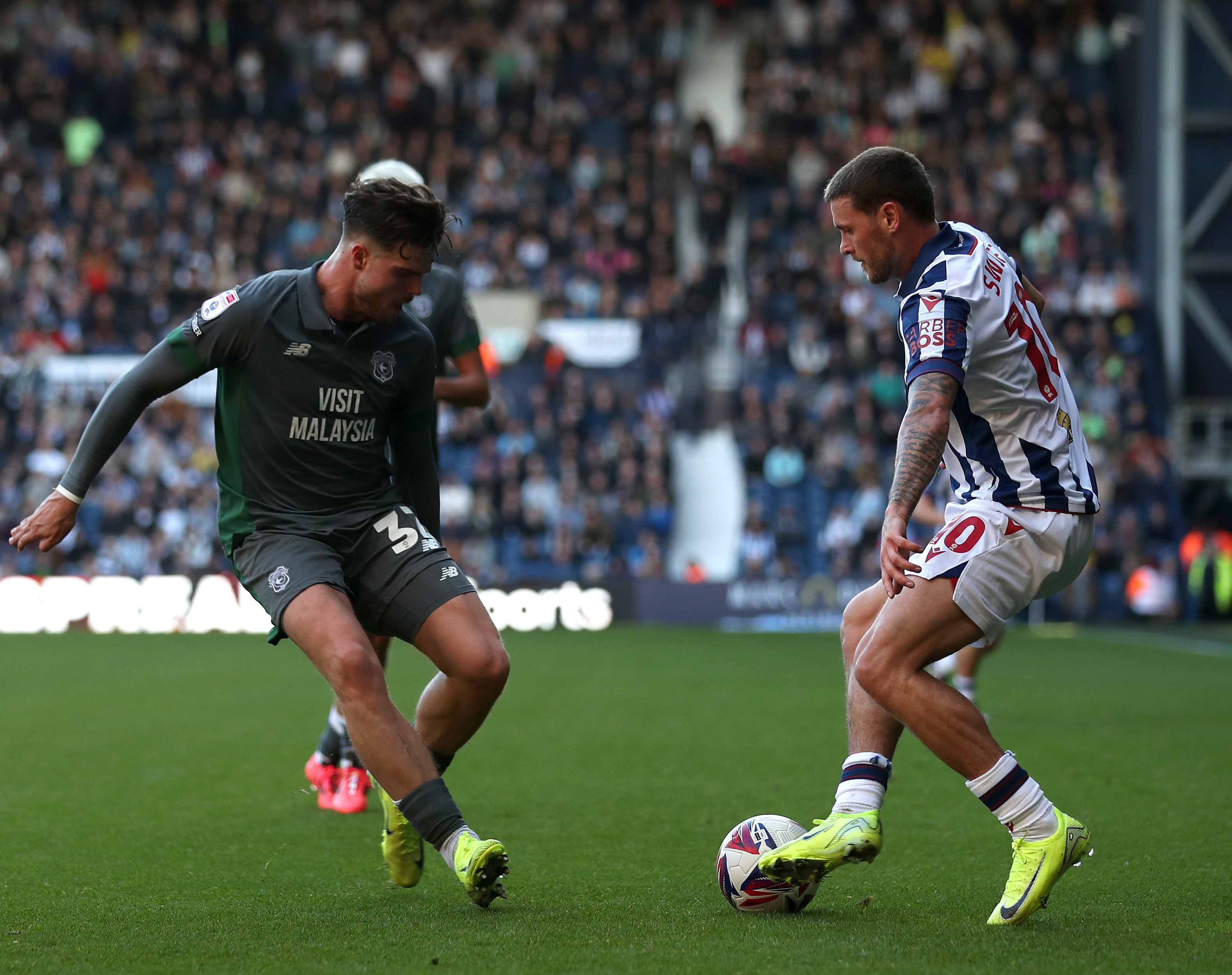 An image of John Swift taking on a Cardiff player