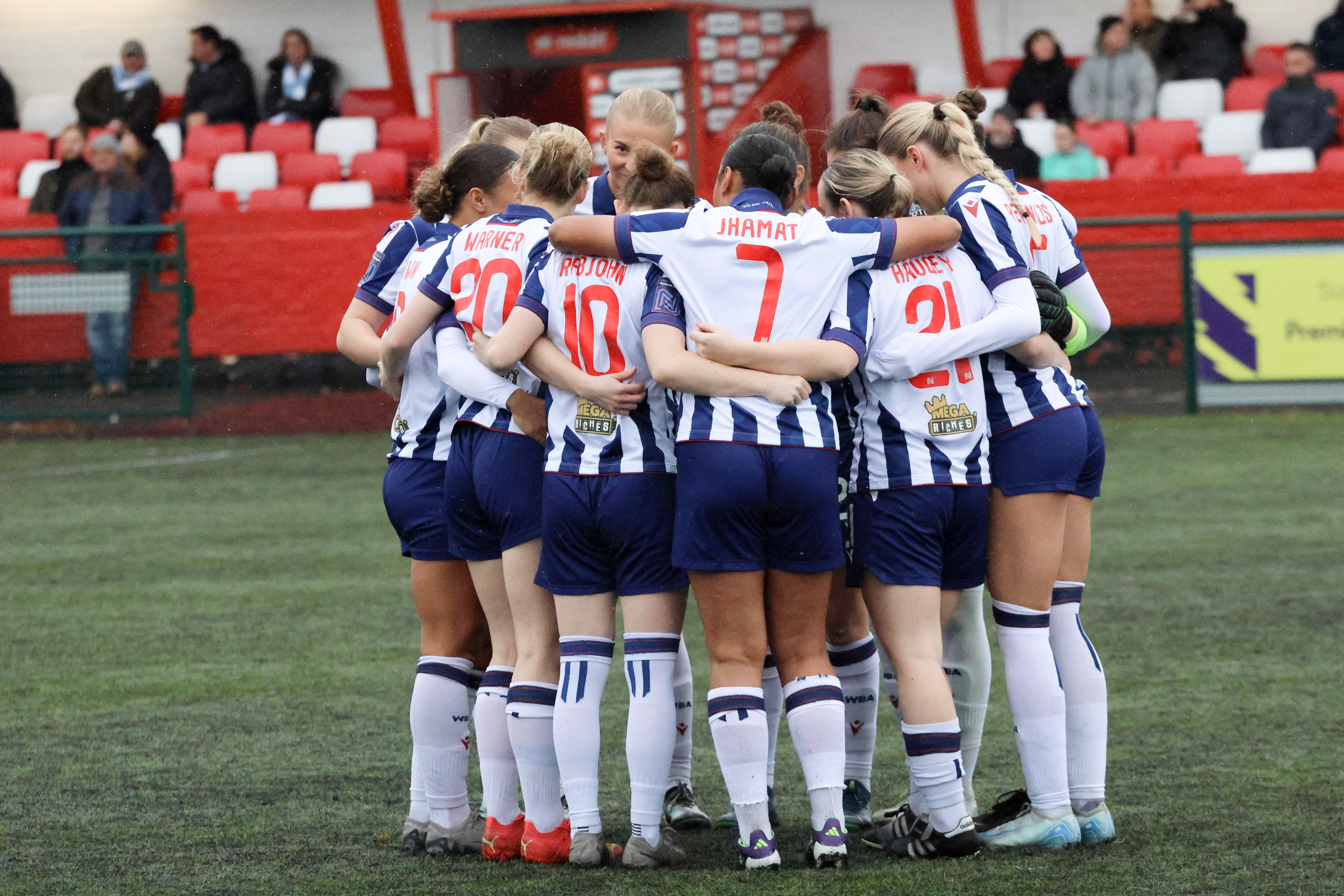 A general view of Albion Women in a huddle before a game wearing the home kit 