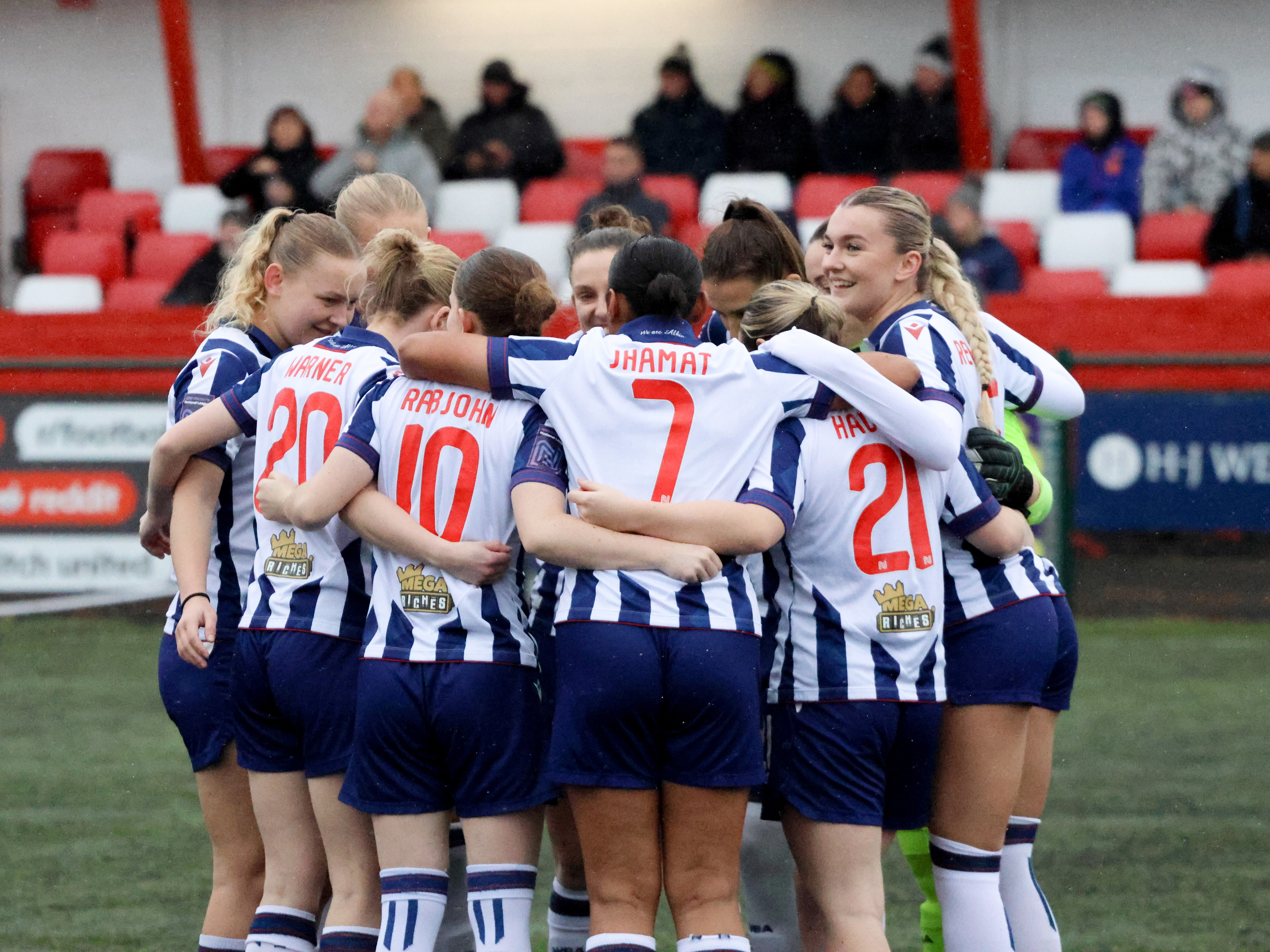 A general view of Albion Women in a huddle before a game wearing the home kit 