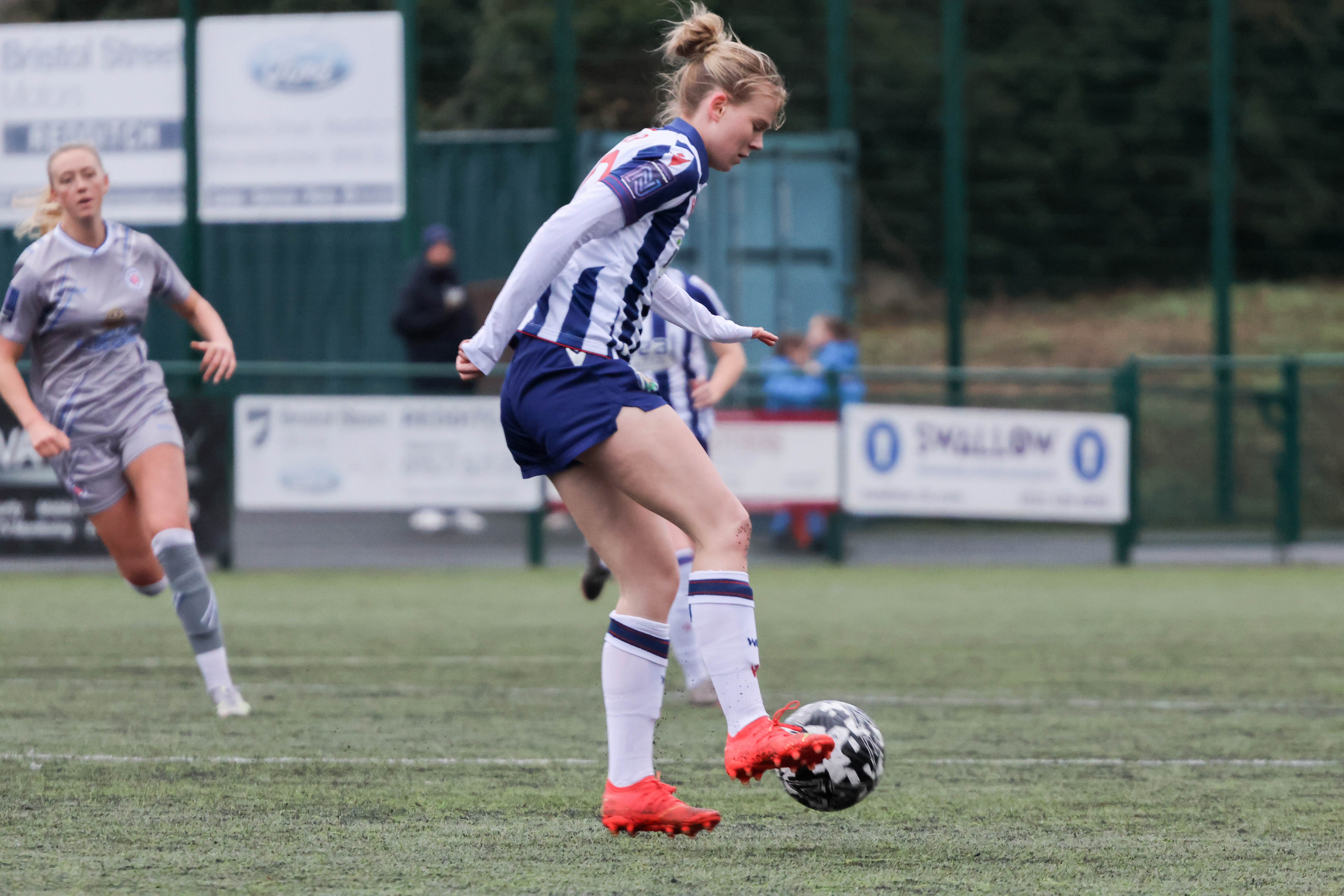 Phoebe Warner on the ball during a game while wearing the home kit 