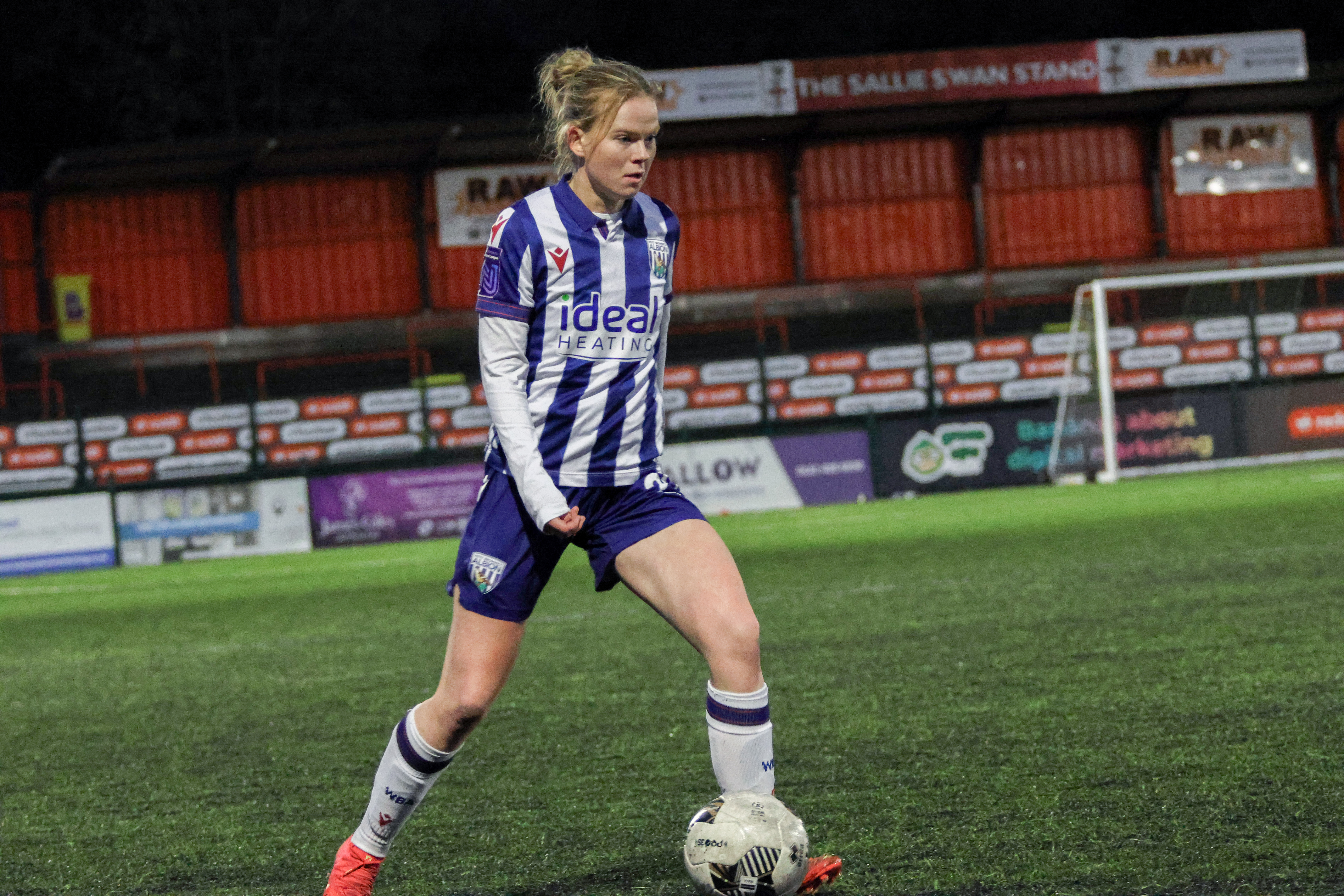 Phoebe Warner on the ball during a game while wearing the home kit 