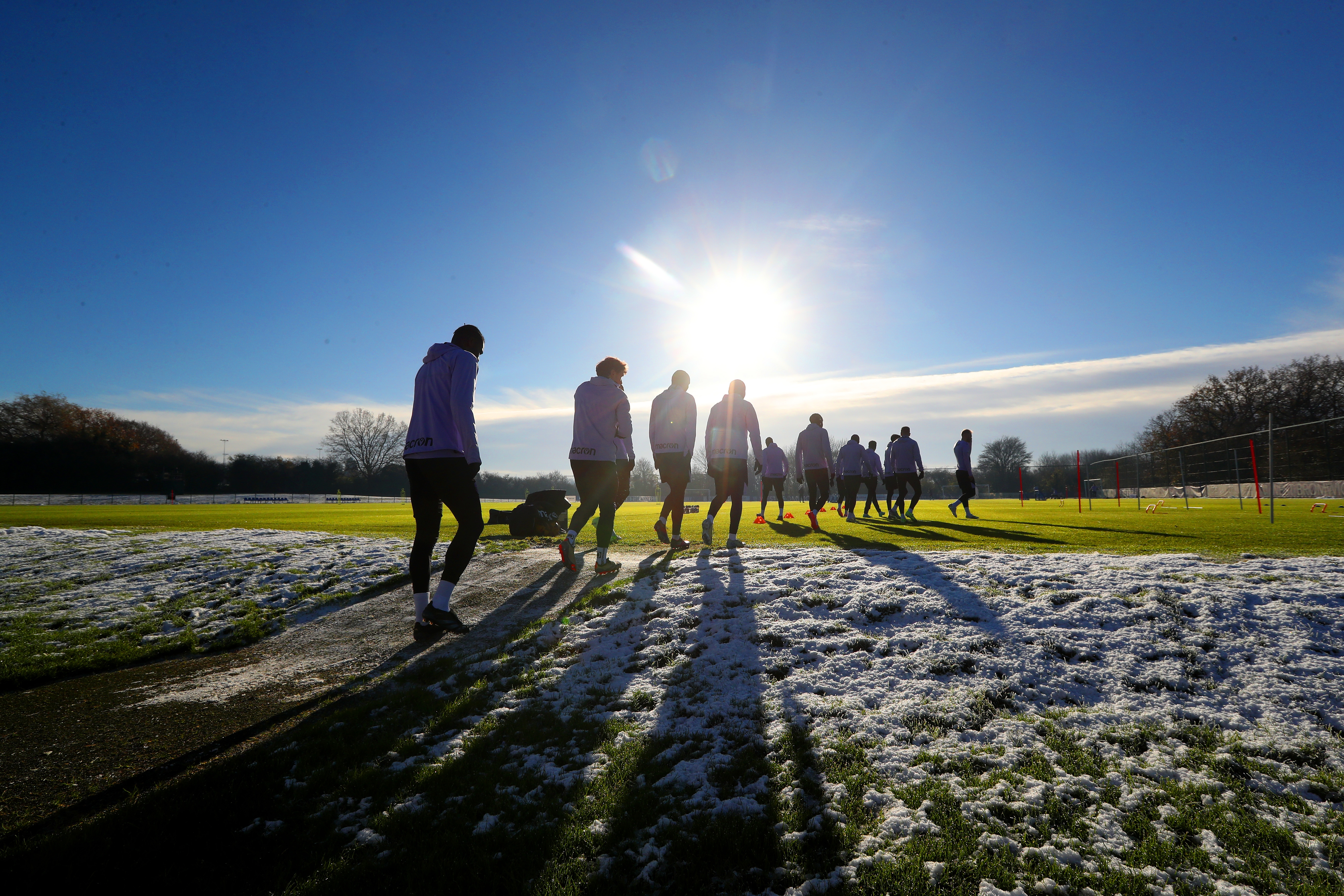 A general view of training in the sunlight with shadows on the pitch 