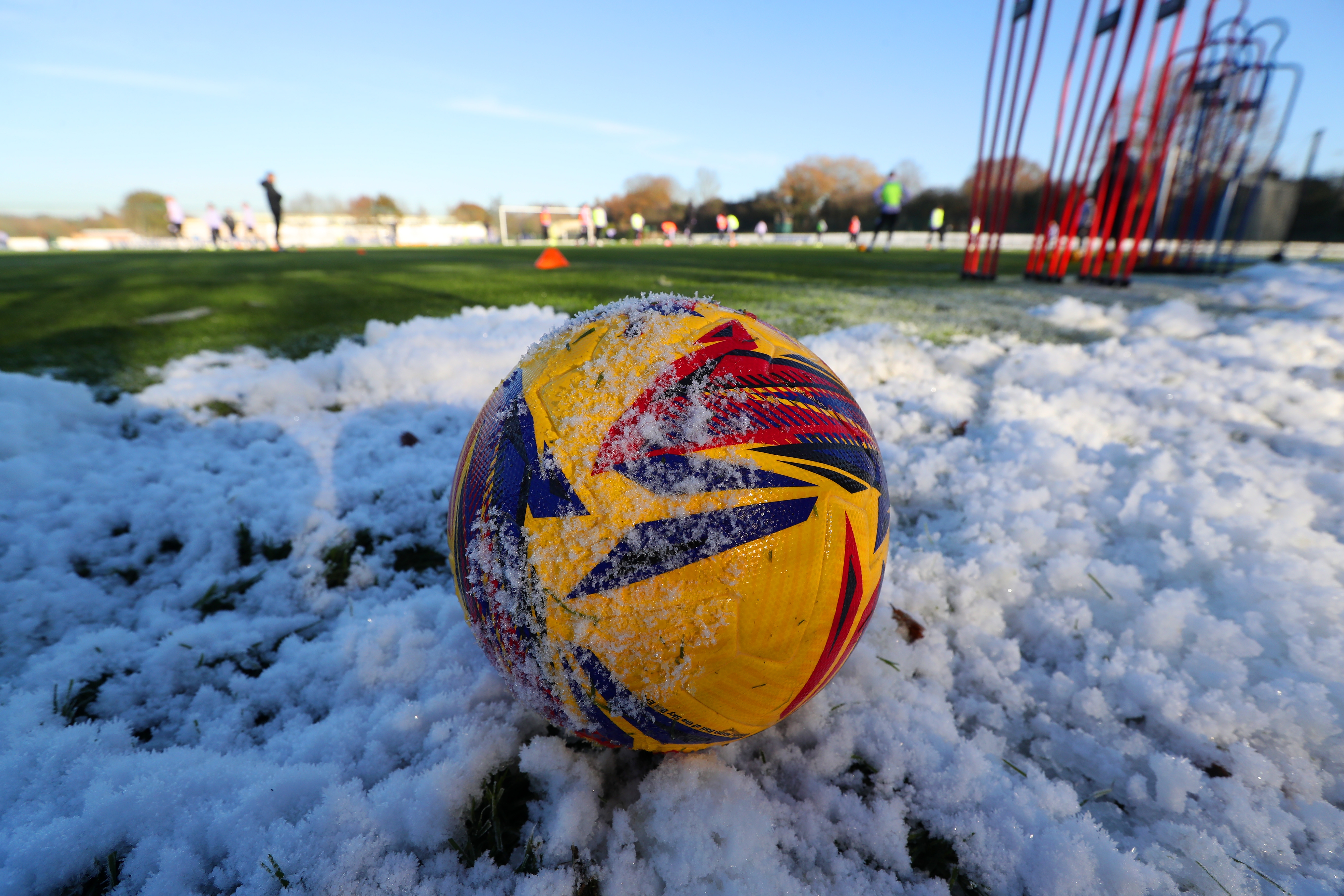 An image of a football covered in snow on the training pitch