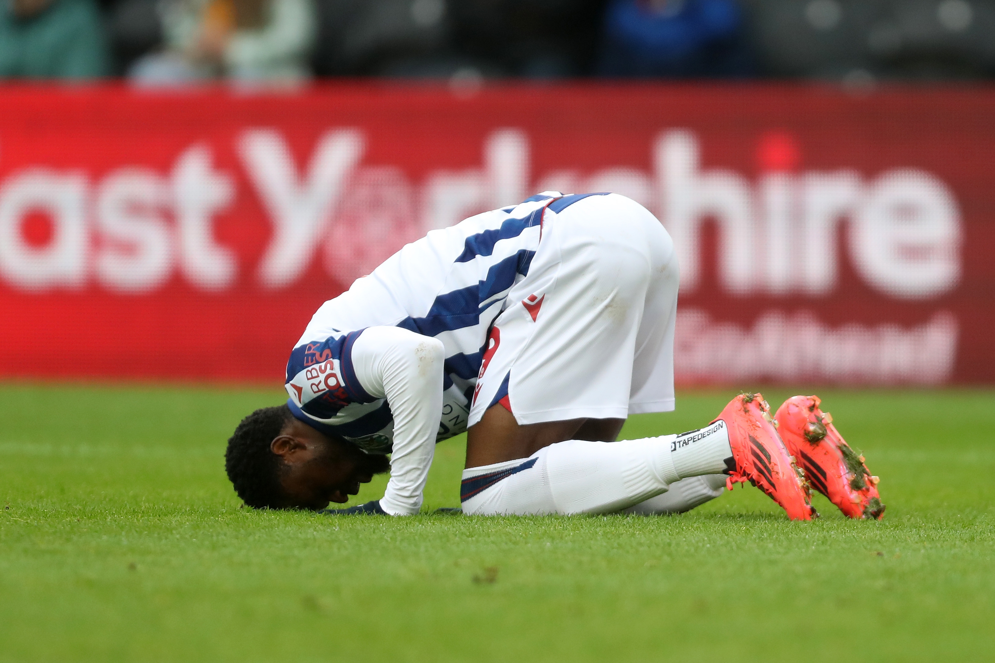 Josh Maja celebrates scoring against Hull by crouching down on the floor with his head in the grass