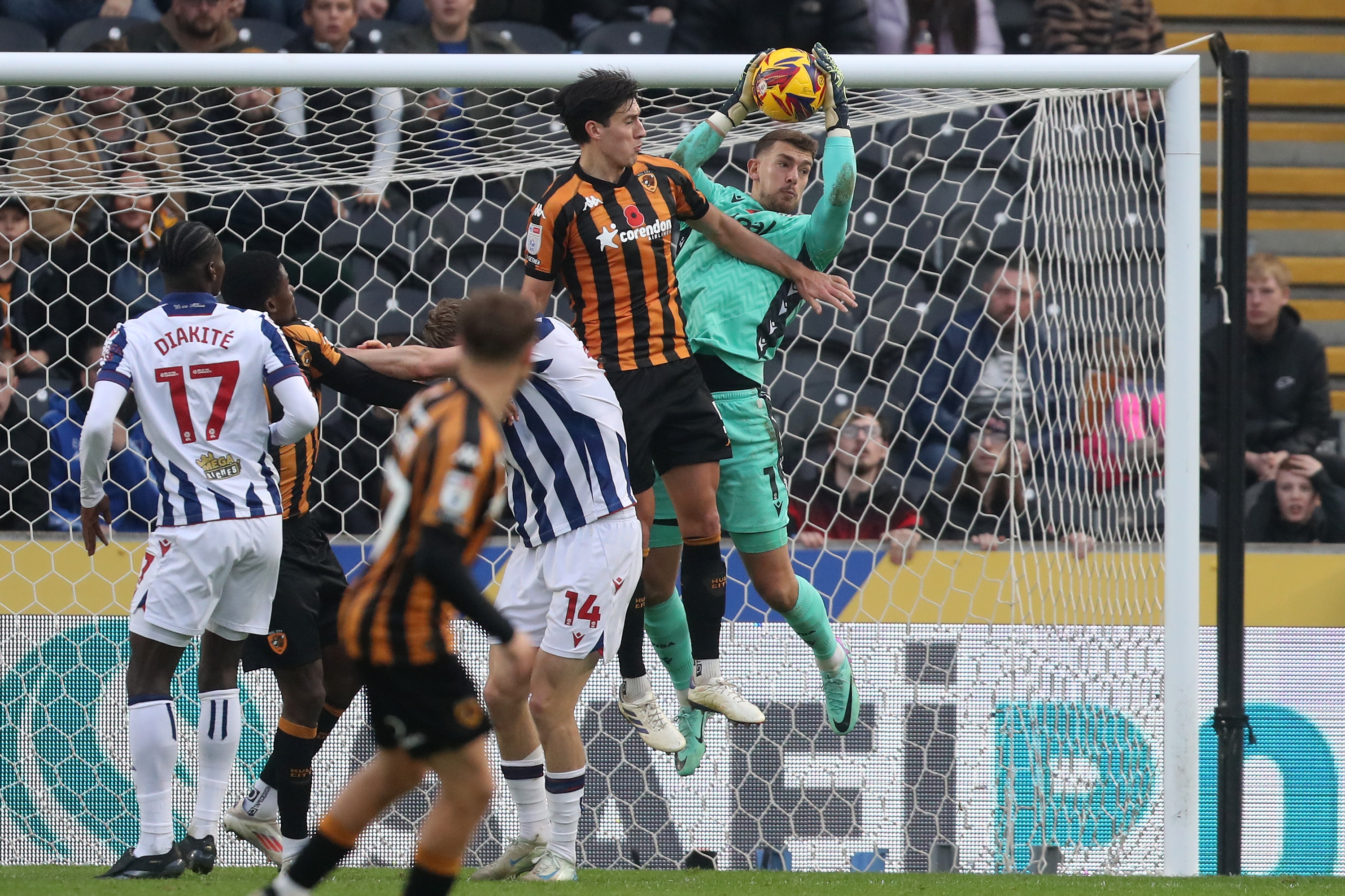 Alex Palmer jumps with a Hull player to try and win the ball