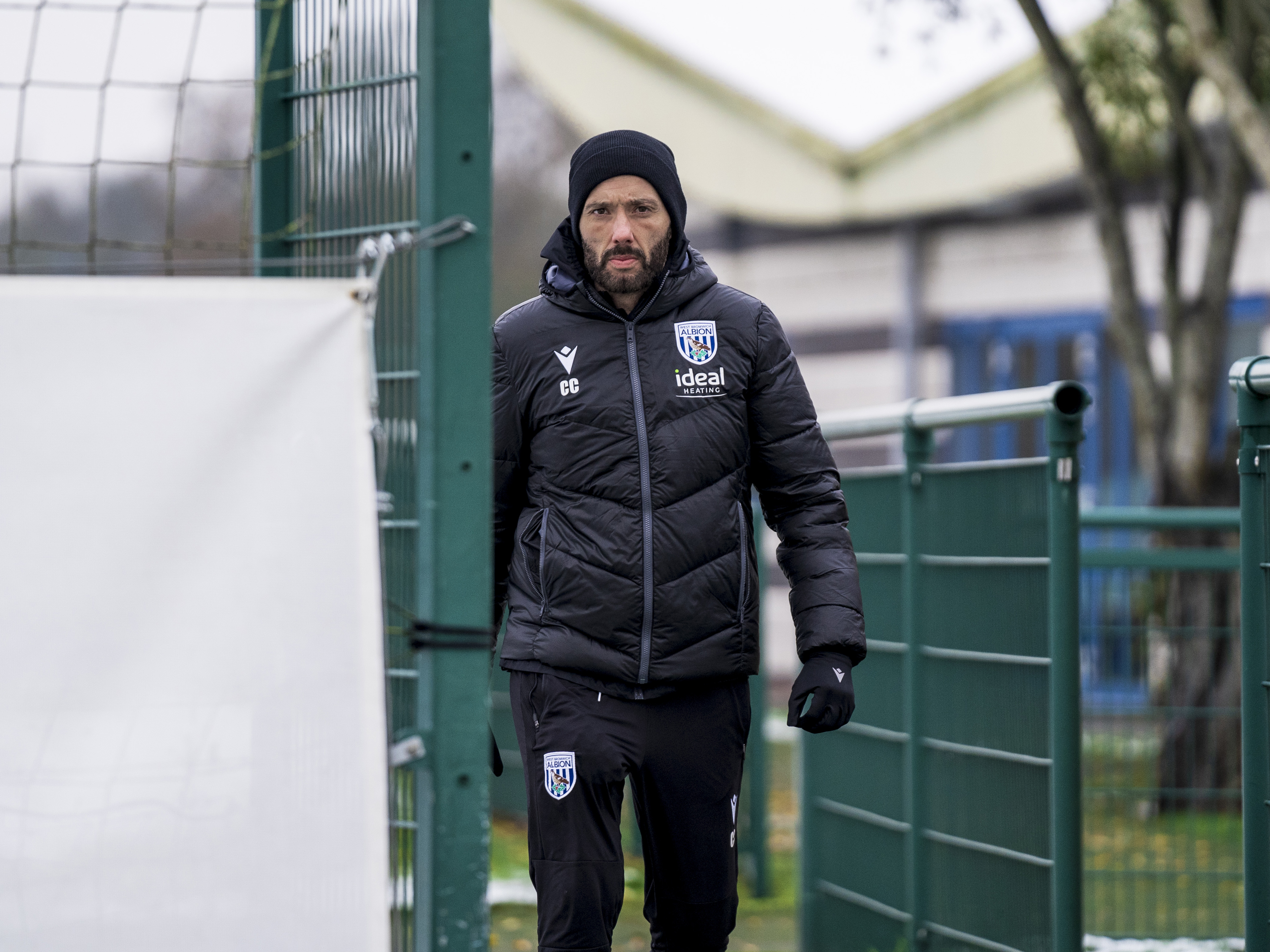 Carlos Corberán heading out to training wearing a coat and a hat