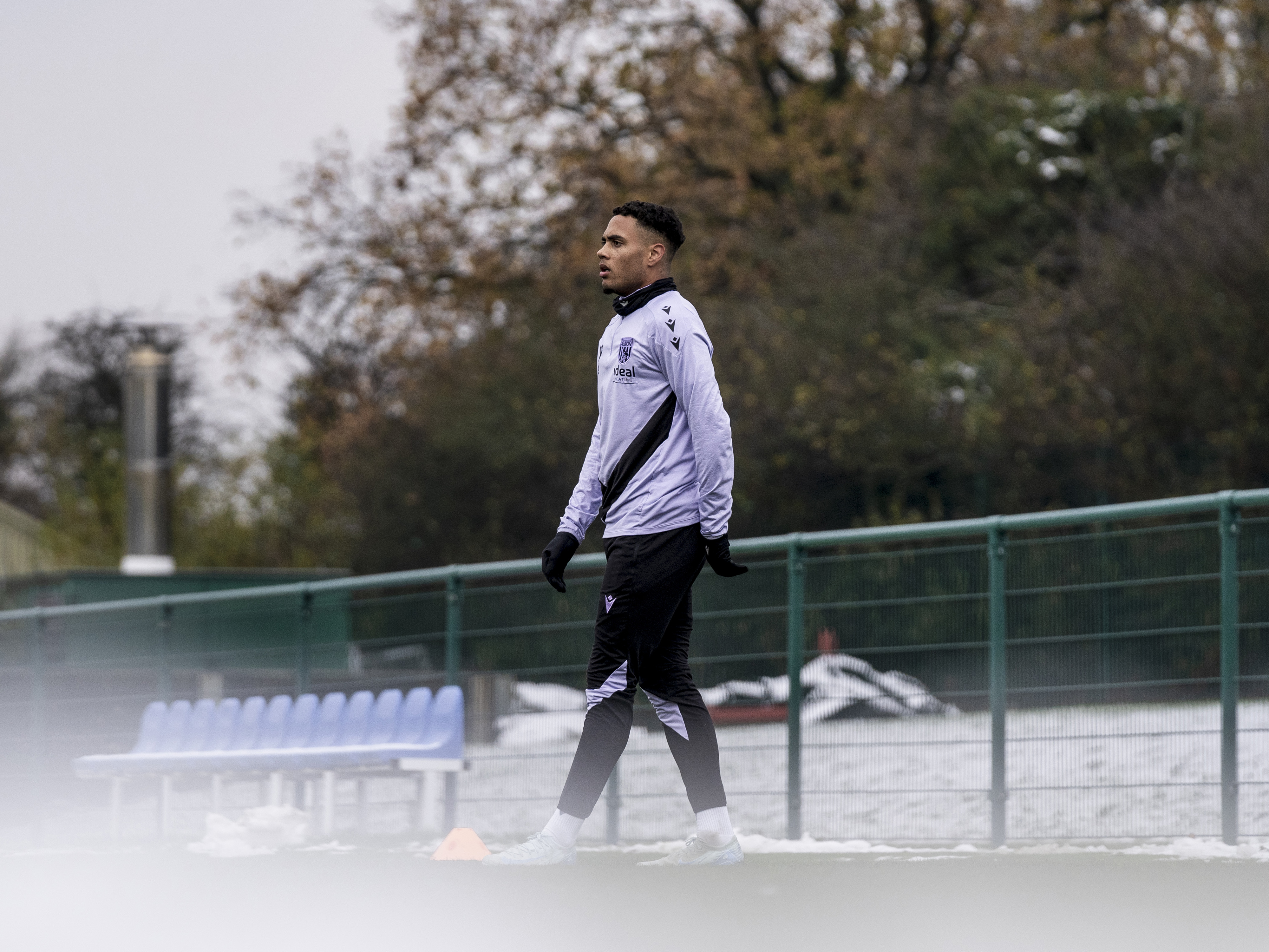 Lewis Dobbin watching training while on the side of the pitch 