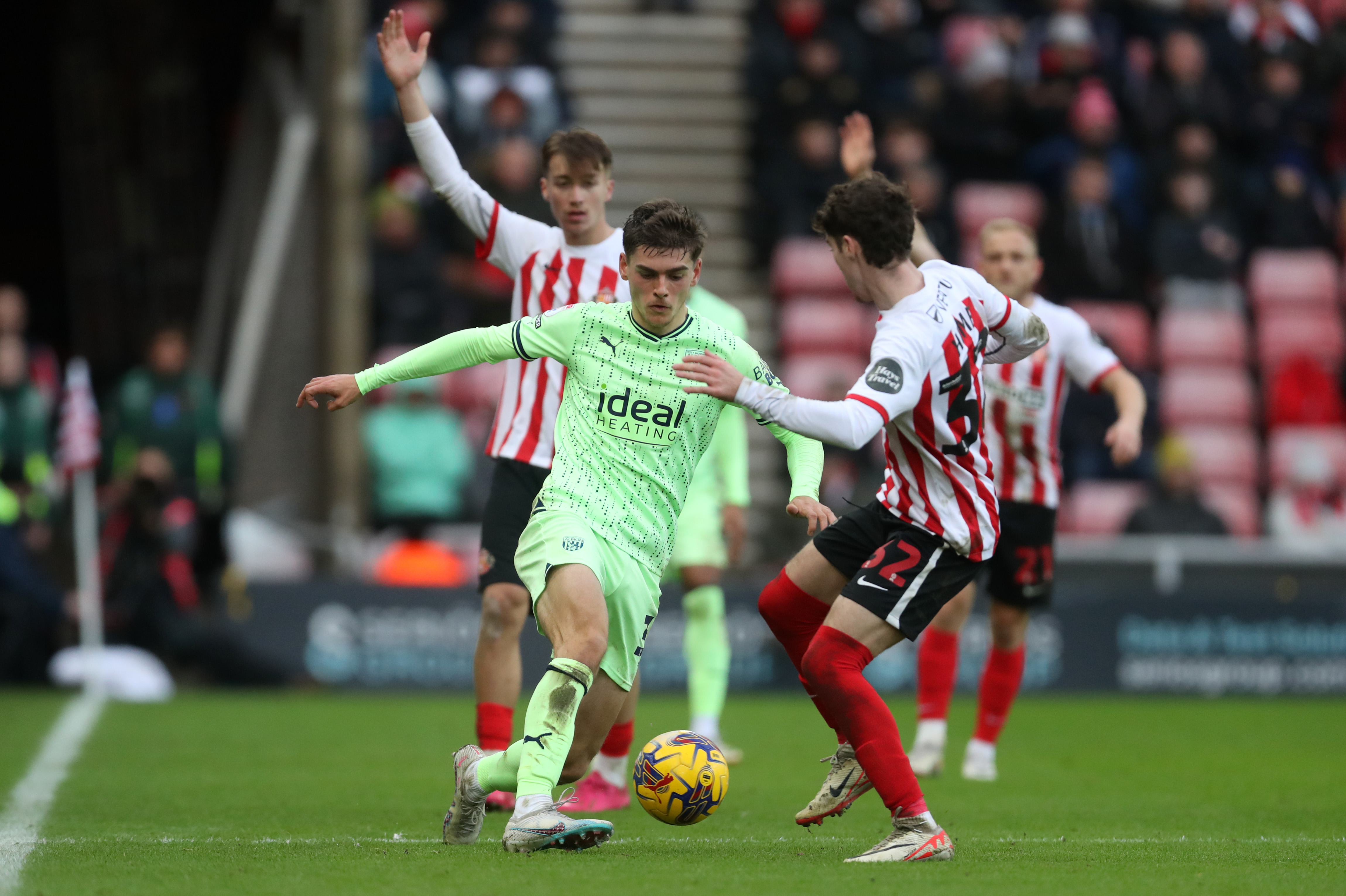 Tom Fellows in action against Sunderland at the Stadium of Light in December 2023 in the lime green away kit 