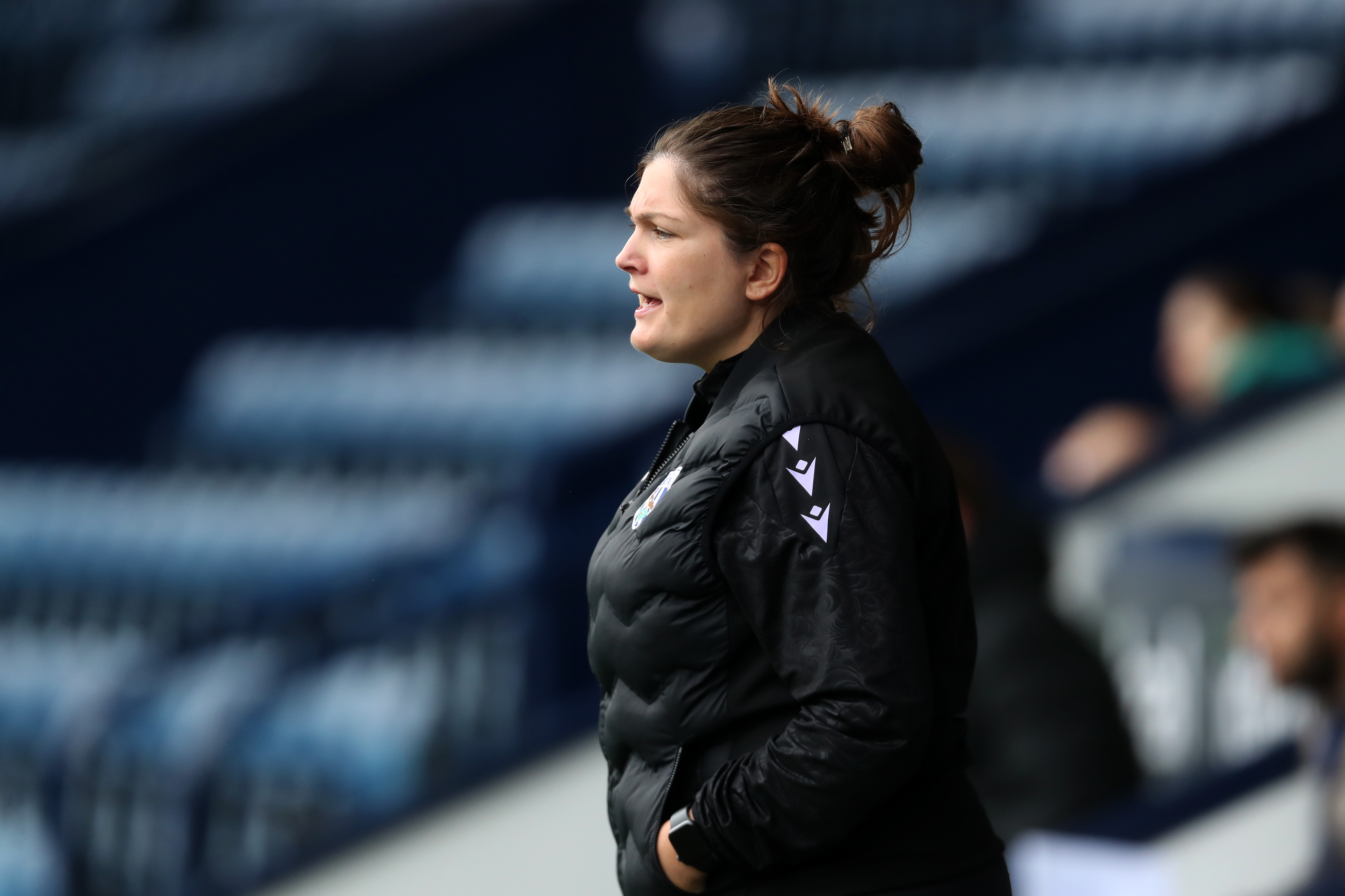 An image of Siobhan Hodgetts-Still stood on the sidelines at The Hawthorns watching a game