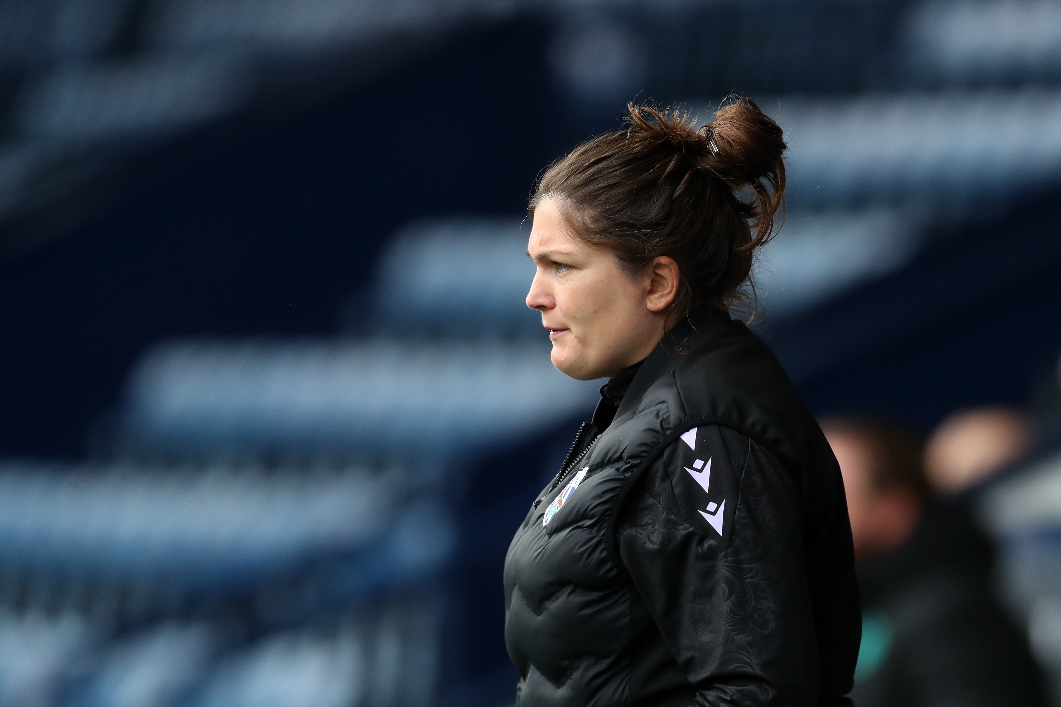 An image of Siobhan Hodgetts-Still stood on the sidelines at The Hawthorns watching a game